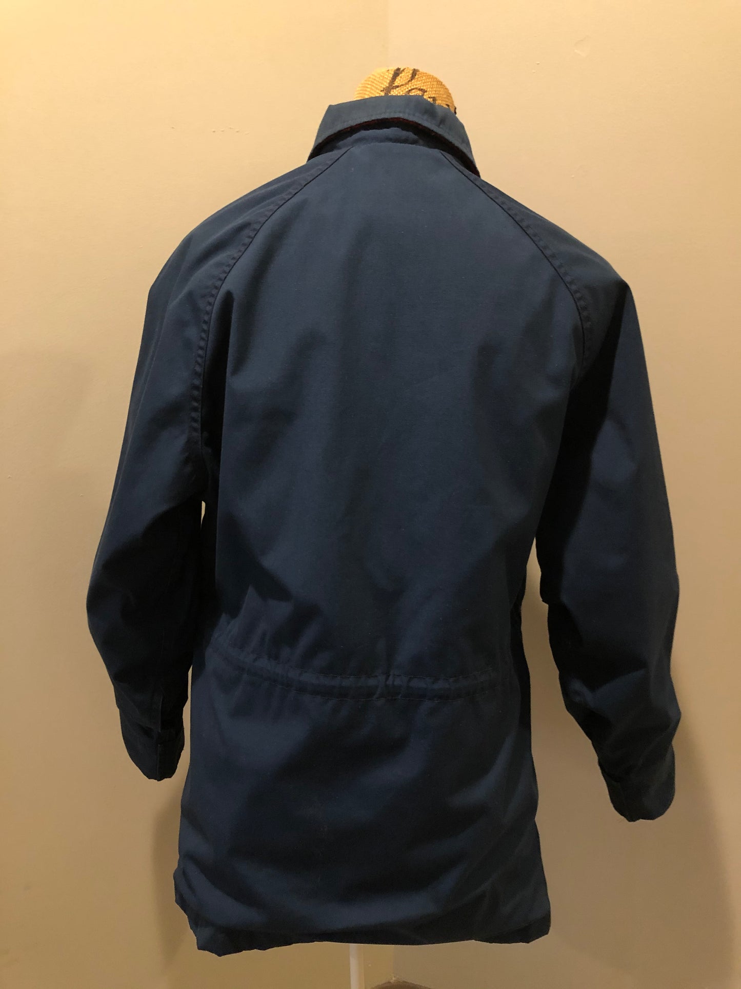 Kingspier Vintage - Woolrich Woman navy jacket with raglan sleeves, hood, zipper, snap closures with sheep logo, two flap pockets, drawstring at waist and red plaid wool lining. Made in the USA. Size medium.