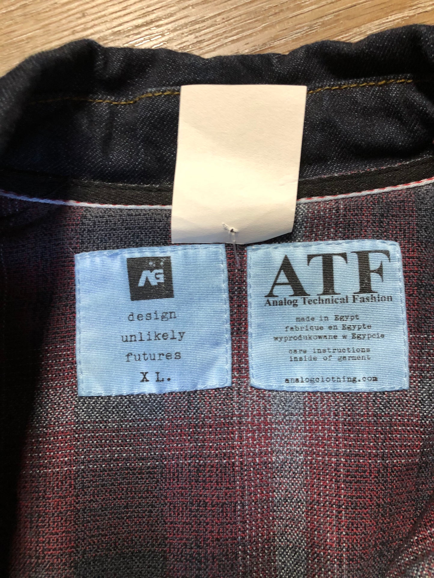 Kingspier Vintage - ATF (Analog Technical Fashion) denim jacket in a dark wash with button closures, two zip slash pockets, two flap pockets, an inside pocket and a plaid lining. Union made. Size XL.