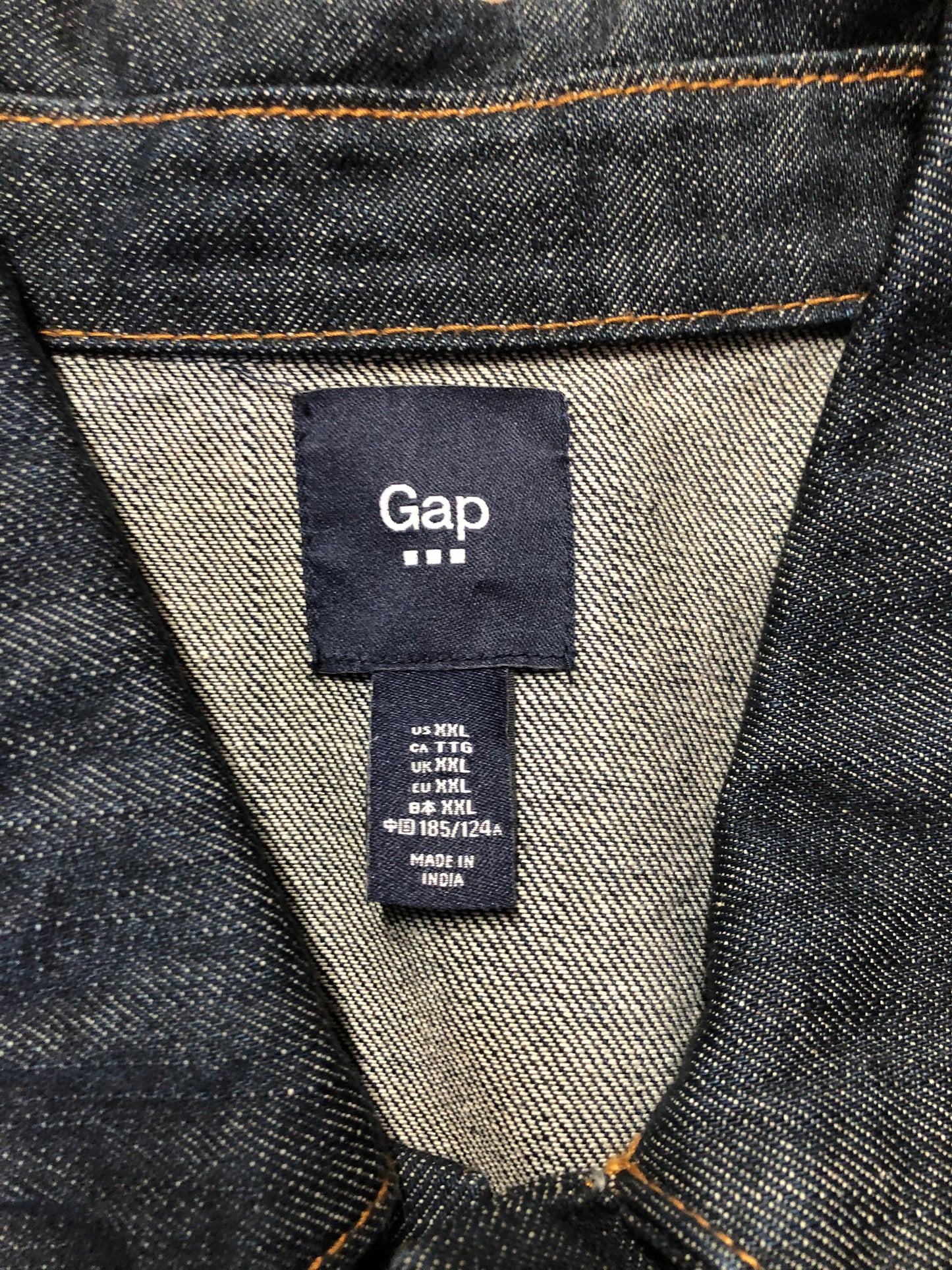 Kingspier Vintage - Gap denim jacket in a dark wash with gold stitching, button closures, two vertical pockets, two flap pockets and two inside pockets. Size XXL.