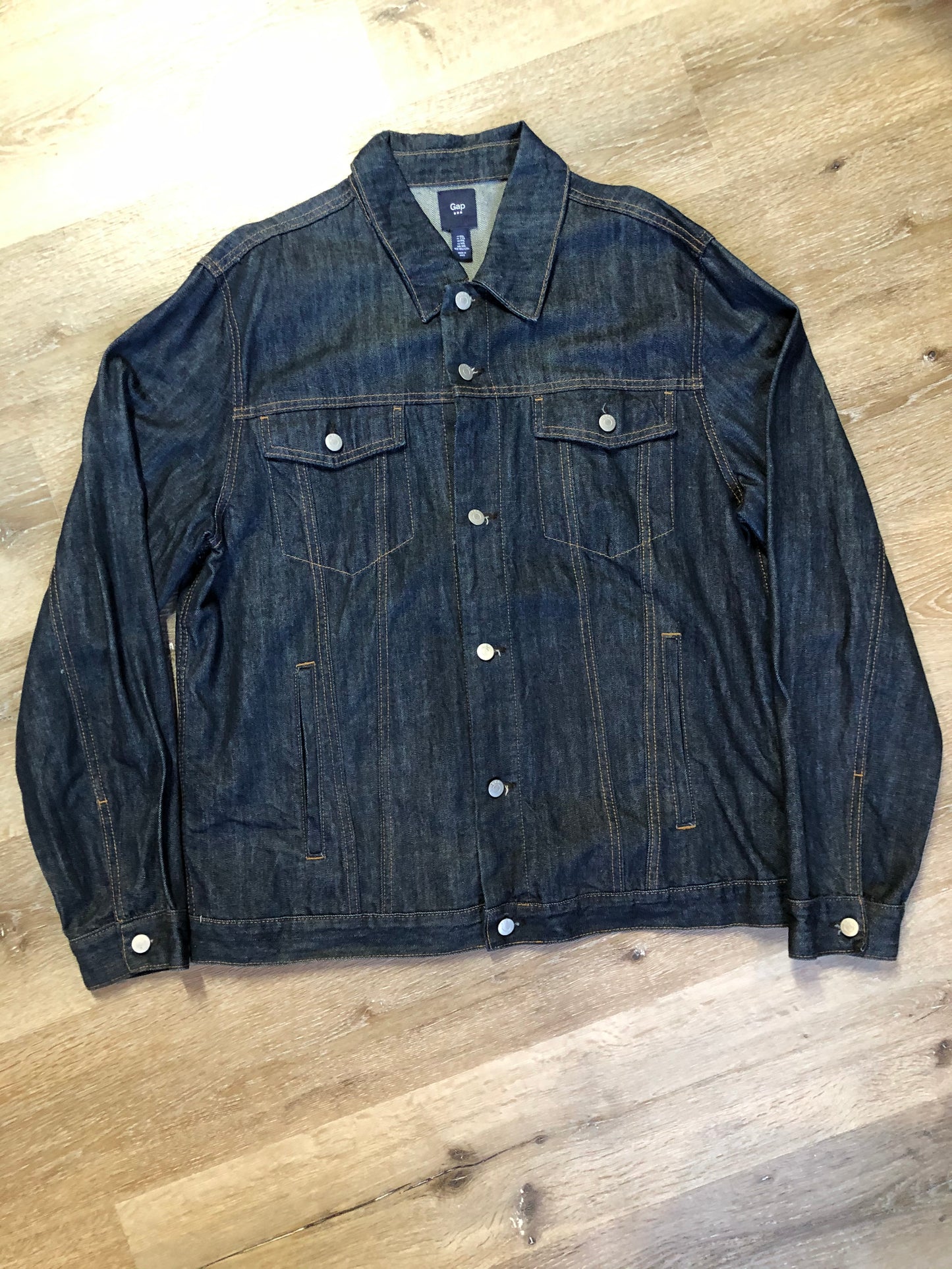 Kingspier Vintage - Gap denim jacket in a dark wash with gold stitching, button closures, two vertical pockets, two flap pockets and two inside pockets. Size XXL.