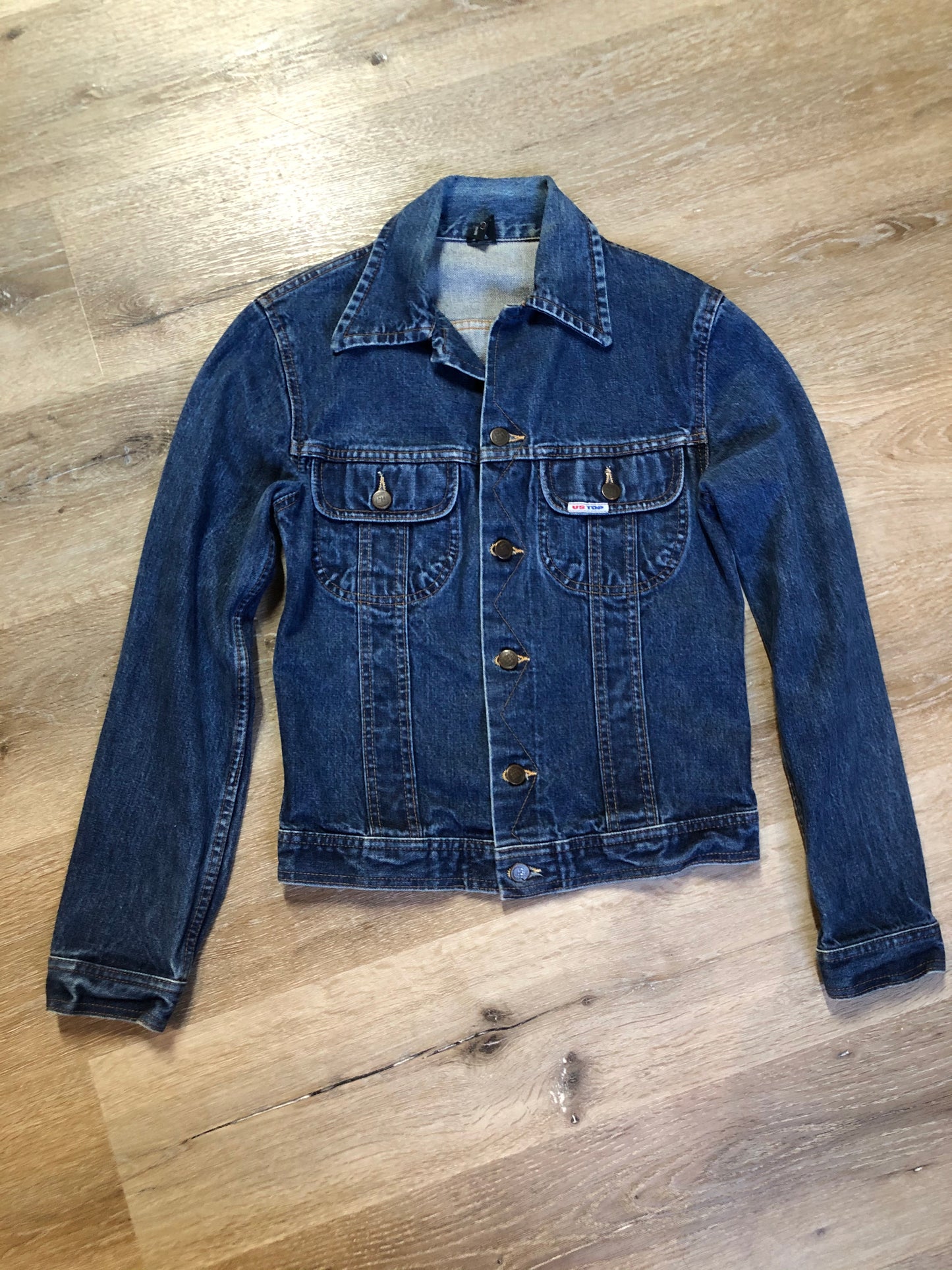 Kingspier Vintage - US Top denim jacket in a medium wash with button closures, two flap pockets on the chest, gold stitching with a unique stitch design down the center front.