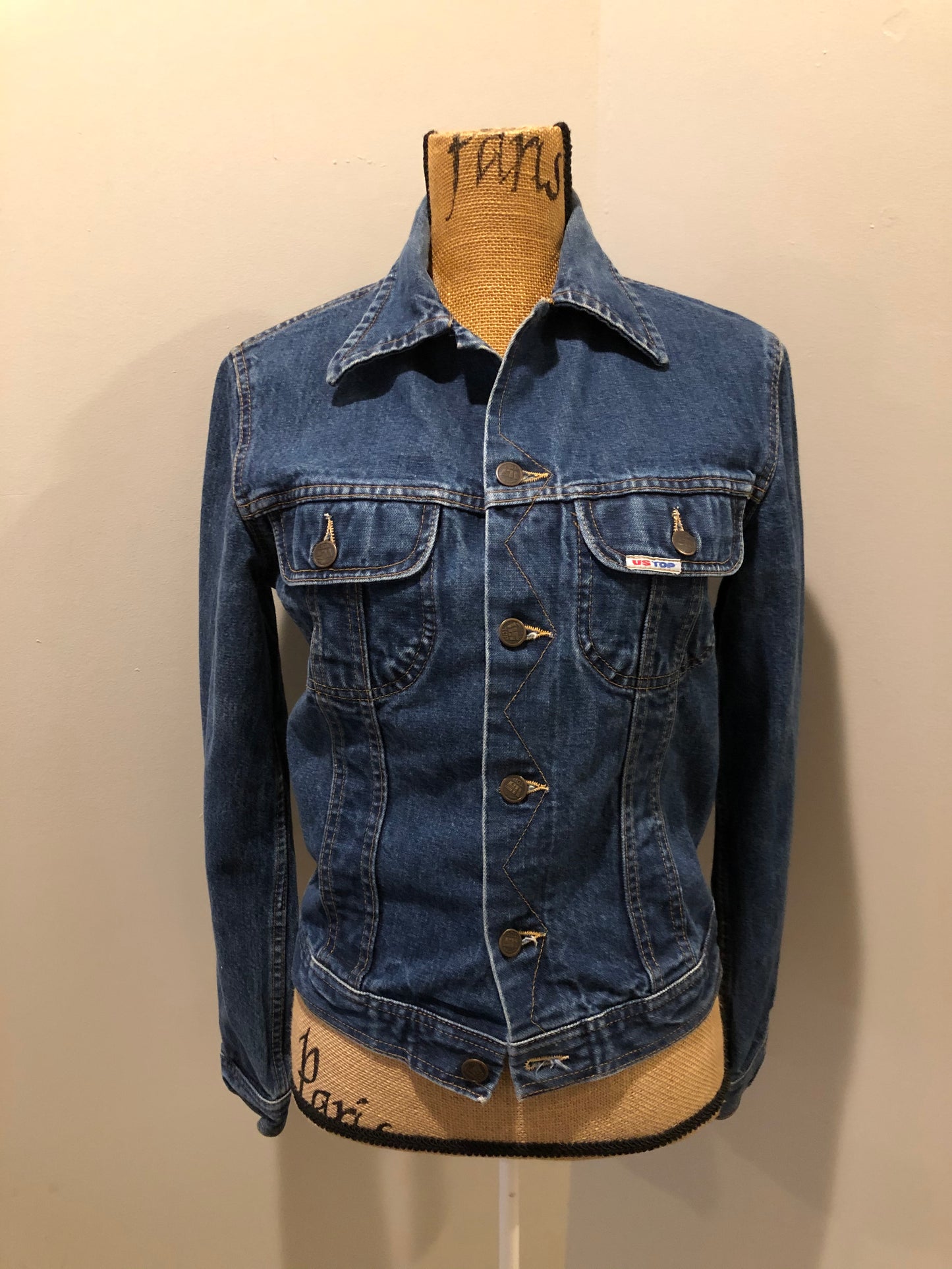 Kingspier Vintage - US Top denim jacket in a medium wash with button closures, two flap pockets on the chest, gold stitching with a unique stitch design down the center front.