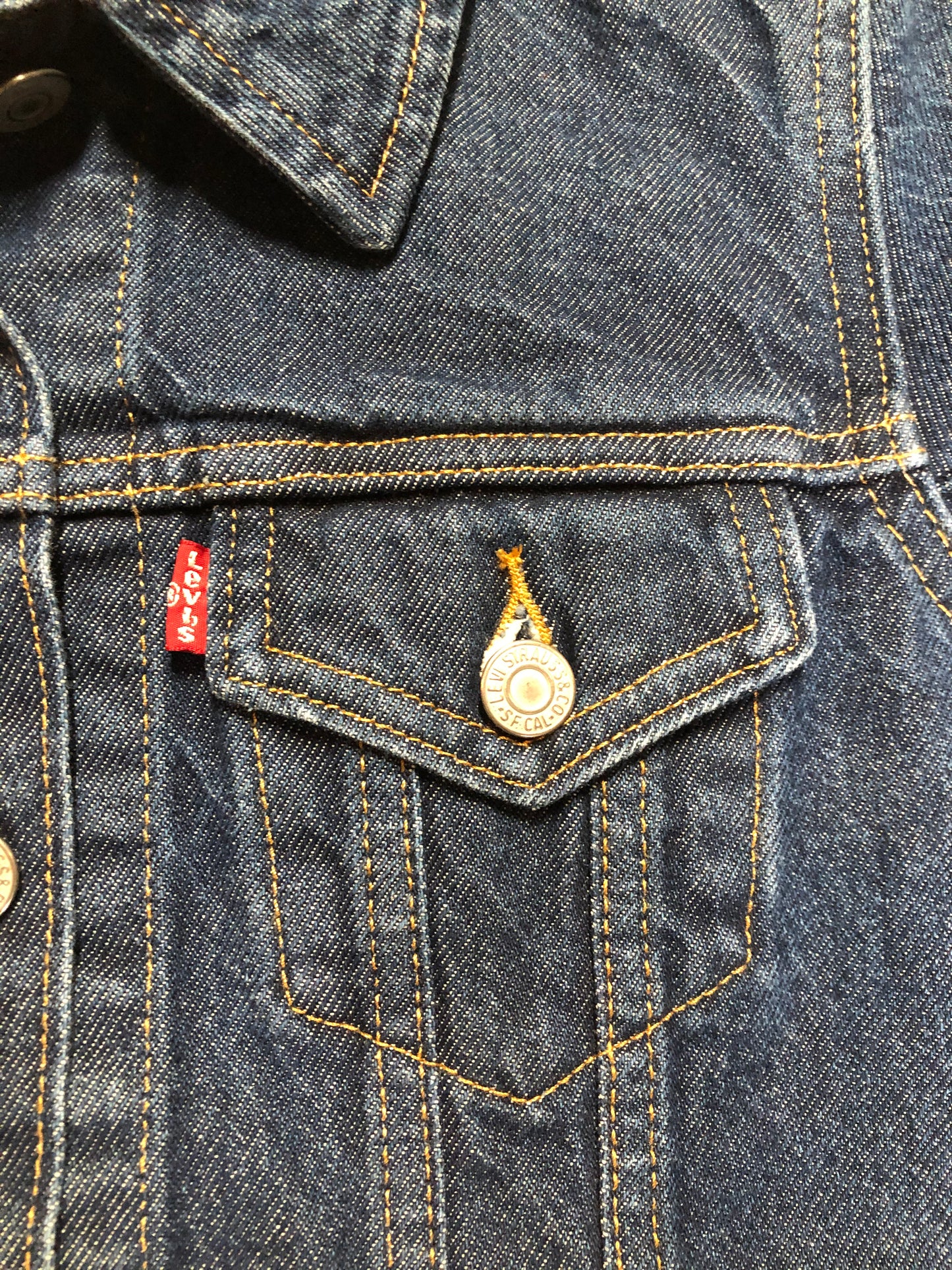 Kingspier Vintage - Levi’s Original Trucker Jacket in a medium wash denim with Canada leaf patch on the left shoulder, button closures, two vertical pockets and two flap pockets on the chest. Size XS.