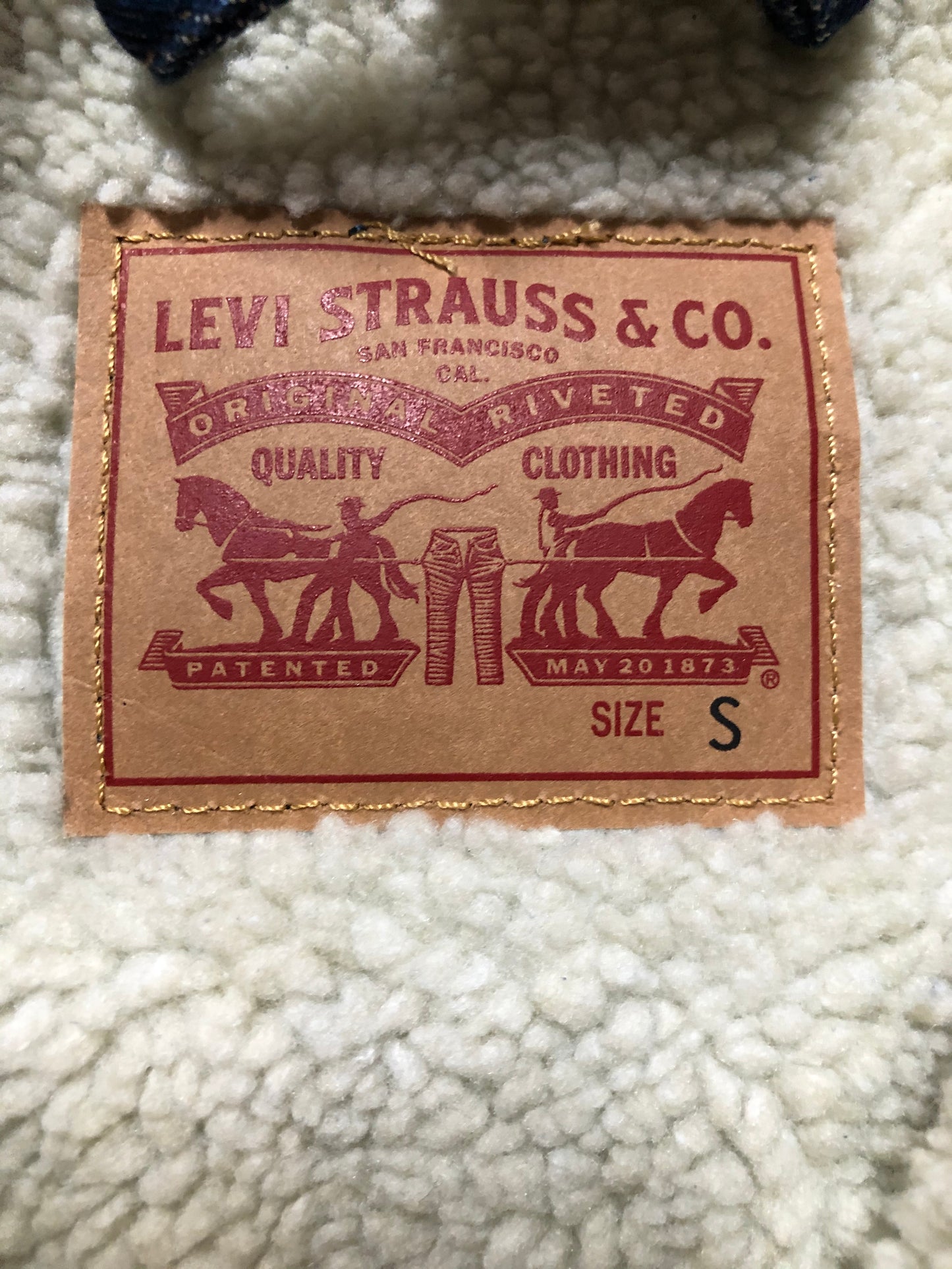Kingspier Vintage - Levi’s denim sherpa trucker jacket in a medium wash with faux fur lining, snap closures, vertical pockets and two flap pockets. Size small.