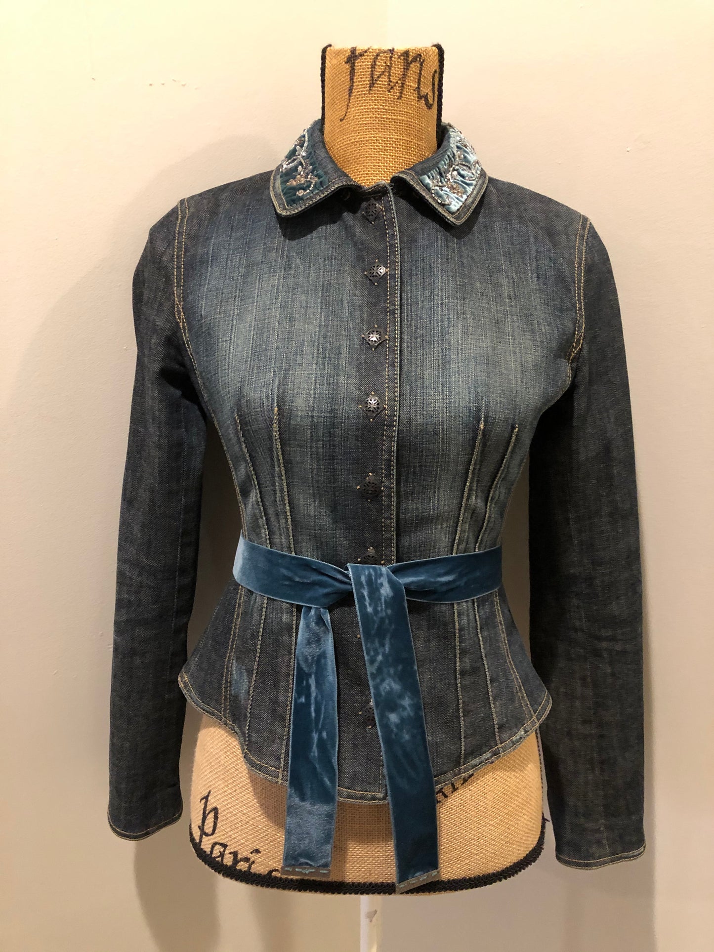 Kingspier Vintage - Elie Tahari denim jacket in a faded dark wash with beaded velvet collar, decorative snap closures, deep green velvet belt and a beautiful patterned silk lining. Size small.