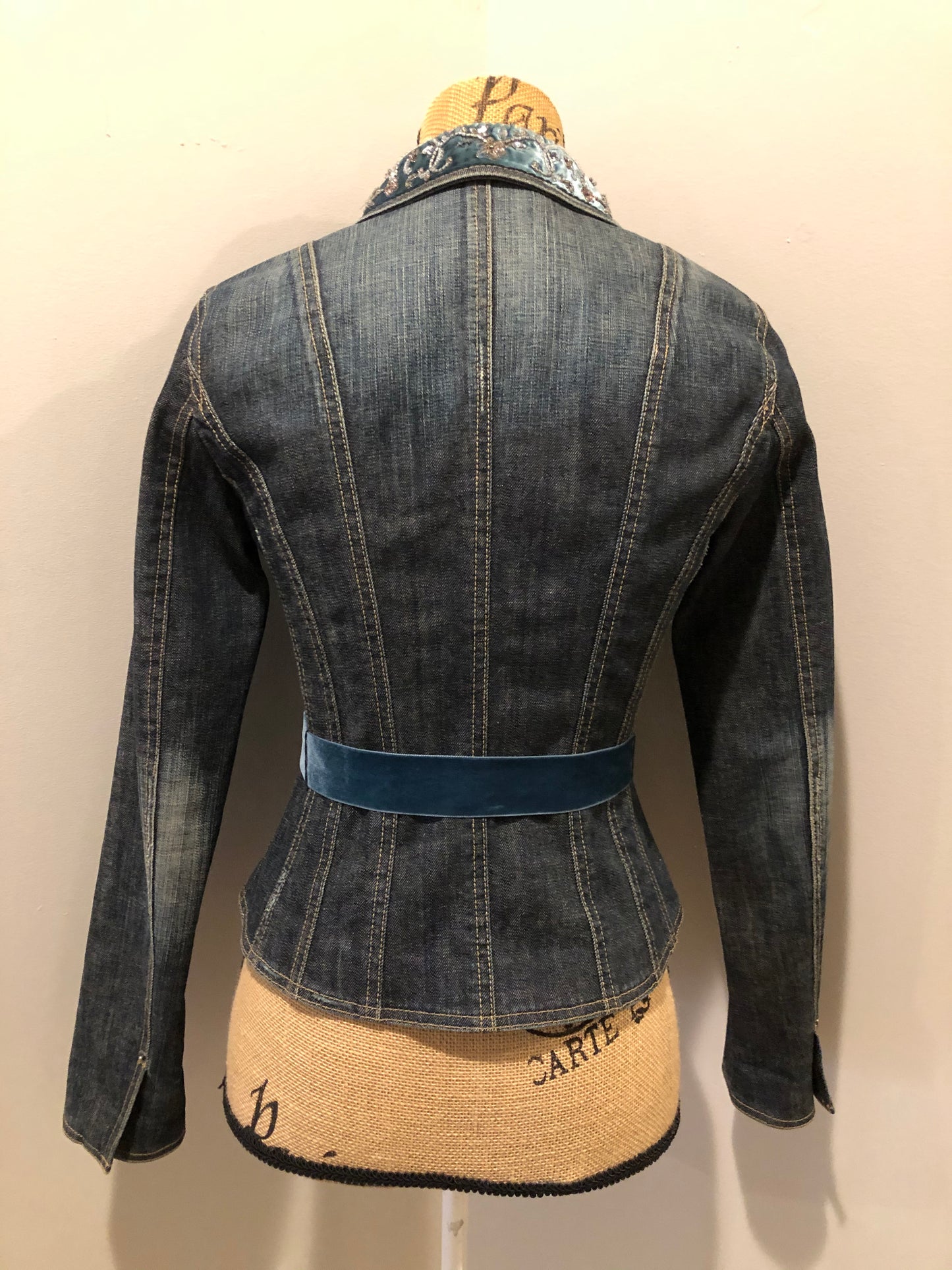 Kingspier Vintage - Elie Tahari denim jacket in a faded dark wash with beaded velvet collar, decorative snap closures, deep green velvet belt and a beautiful patterned silk lining. Size small.