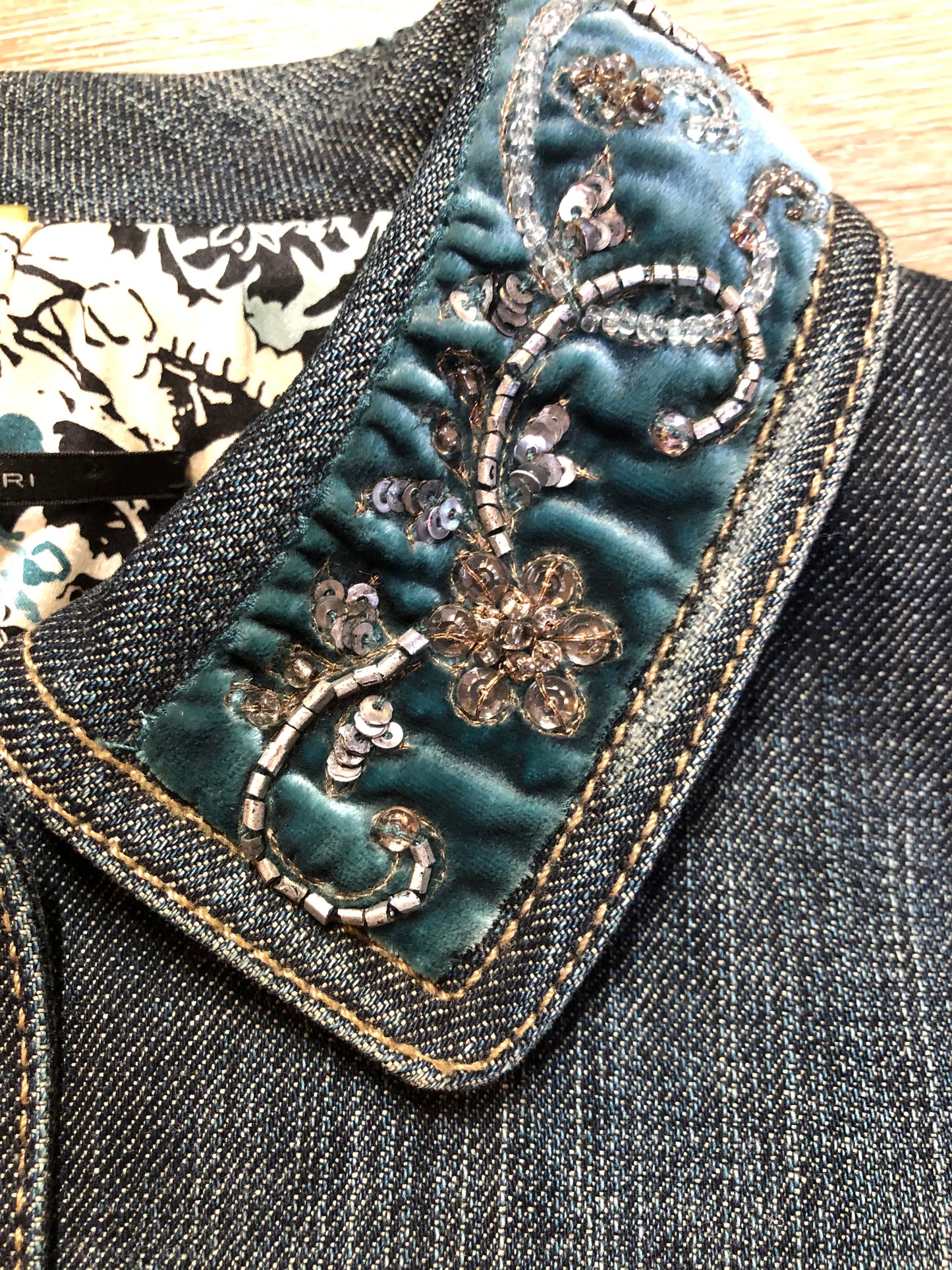 Kingspier Vintage - Elie Tahari denim jacket in a faded dark wash with beaded velvet collar, decorative snap closures, deep green velvet belt and a beautiful patterned silk lining. Size small.
