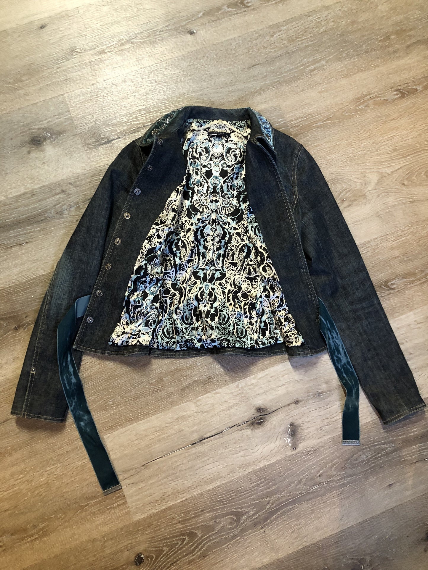 Kingspier Vintage - Elie Tahari denim jacket in a faded dark wash with beaded velvet collar, decorative snap closures, deep green velvet belt and a beautiful patterned silk lining. Size small.