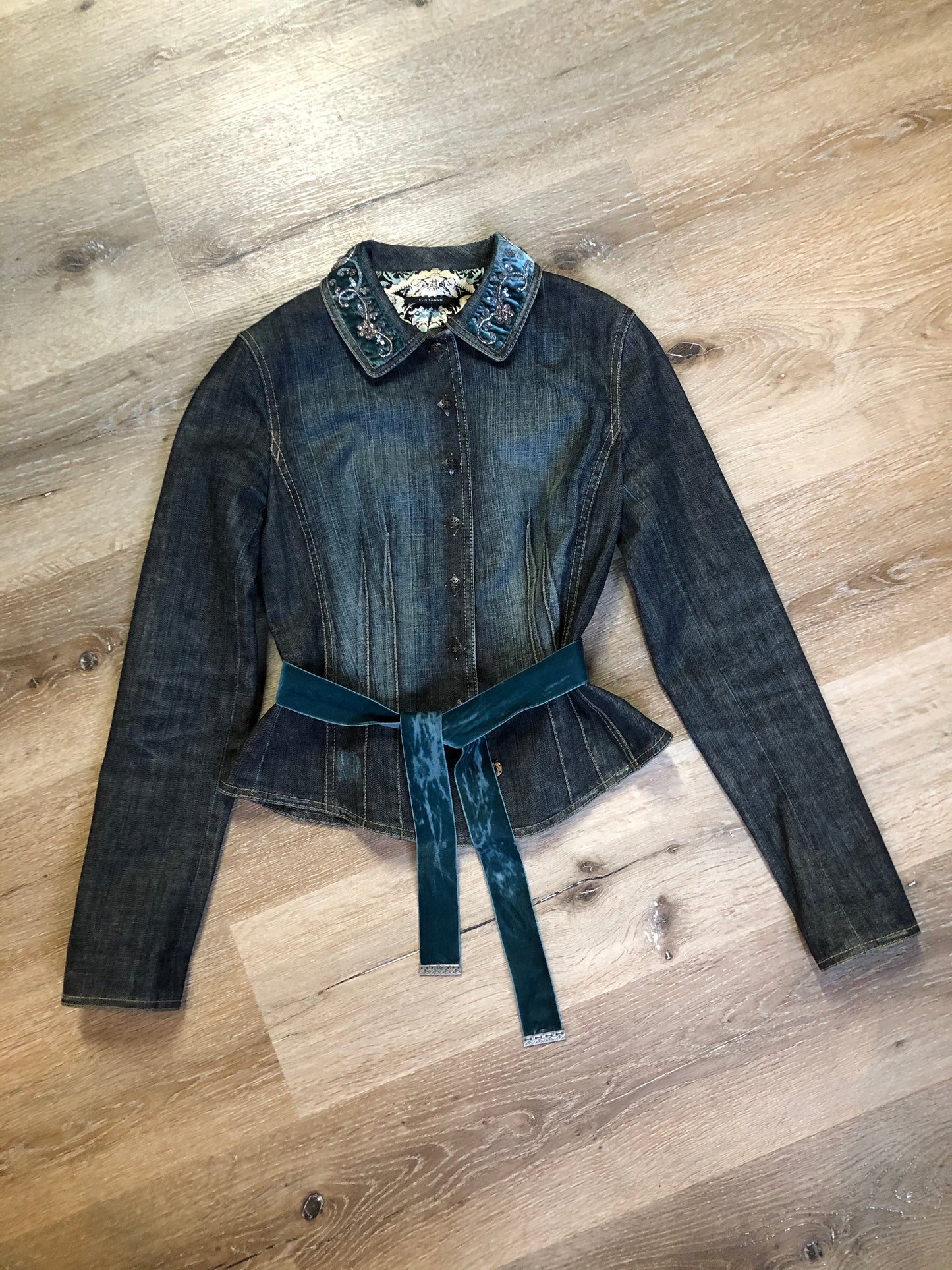 Kingspier Vintage - Elie Tahari denim jacket in a faded dark wash with beaded velvet collar, decorative snap closures, deep green velvet belt and a beautiful patterned silk lining. Size small.\