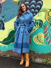 Load image into Gallery viewer, Kingspier Vintage - Hudson’s Bay Company blue and black stripe 100% virgin wool point blanket coat in a swing coat style with belt, buckle detail at the collar, button closures, slash pockets and blue satin lining. Made in England. Size large.
