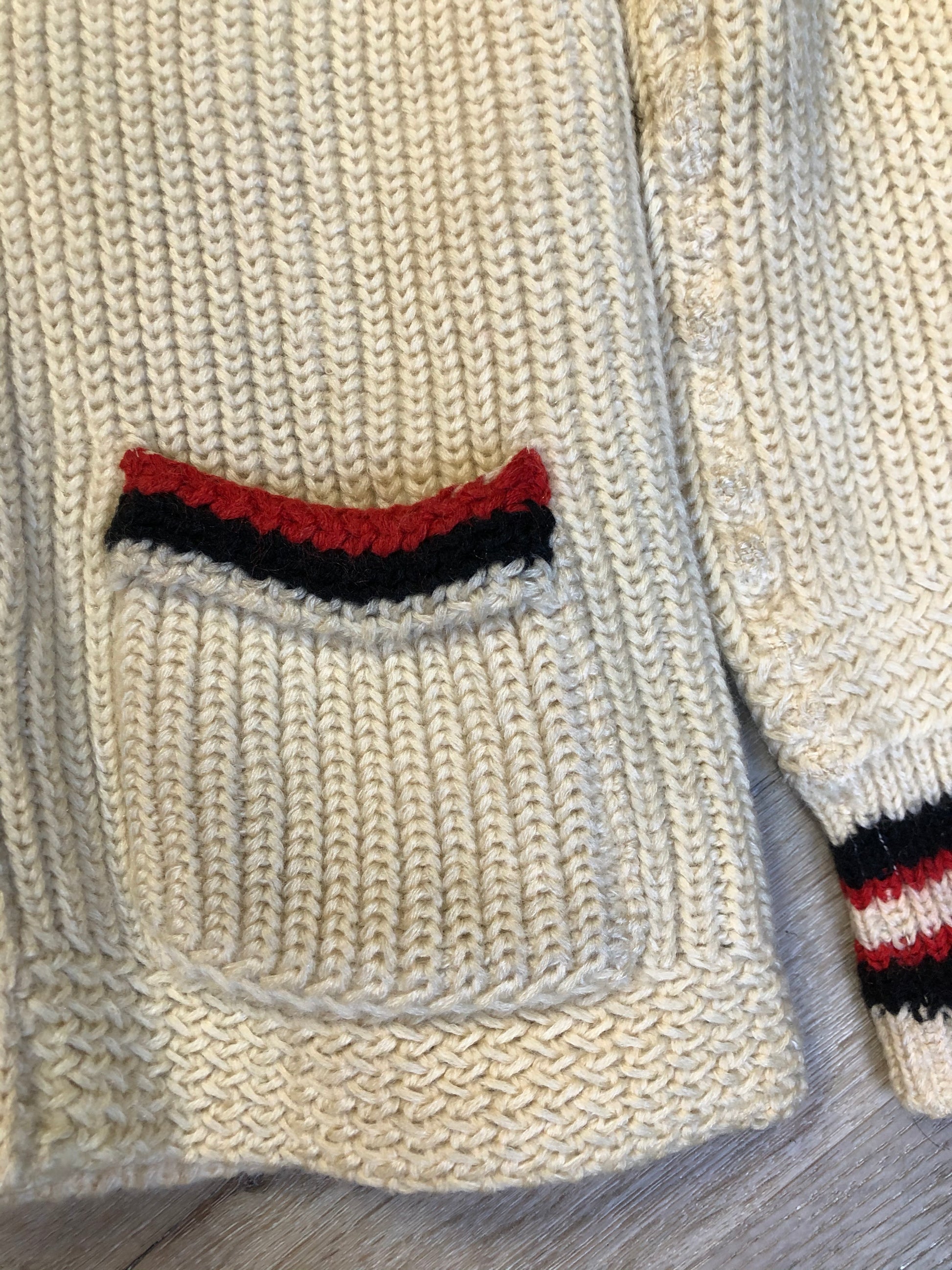 Kingspier Vintage - Curl-Rite by Rice-Knit Sportswear 1950’s curing sweater in cream with red and black strip details, shawl collar, button closures and pockets. 100% wool. Size medium. Made in Nova Scotia.