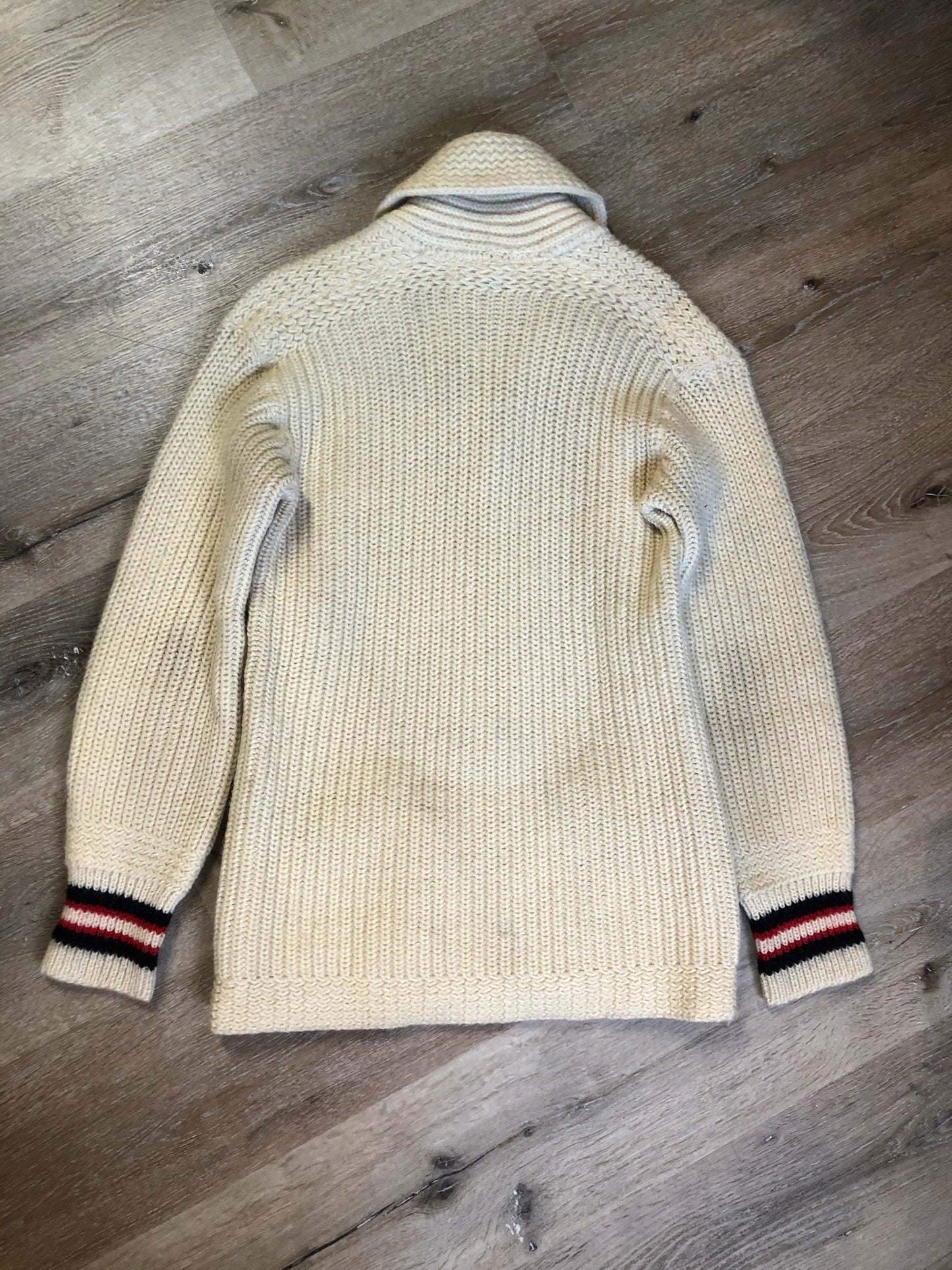 Kingspier Vintage - Curl-Rite by Rice-Knit Sportswear 1950’s curing sweater in cream with red and black strip details, shawl collar, button closures and pockets. 100% wool. Size medium. Made in Nova Scotia.