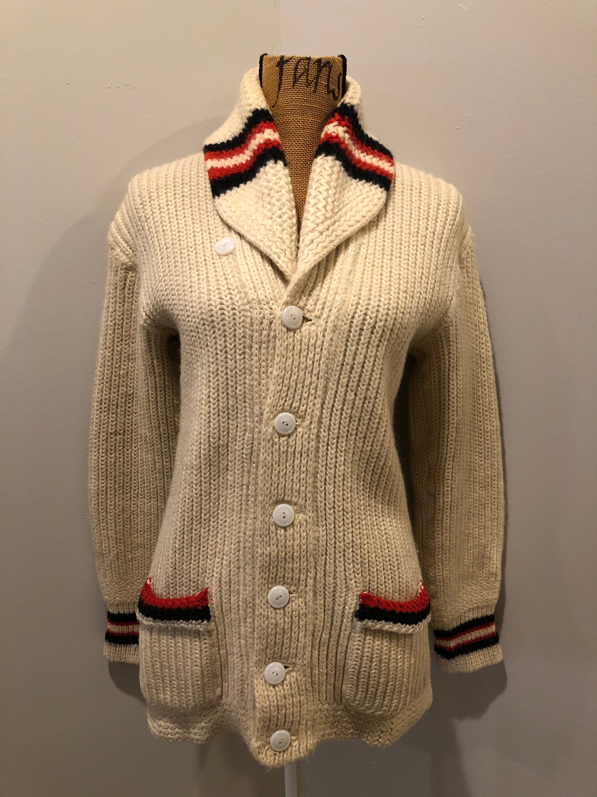 Kingspier Vintage - Curl-Rite by Rice-Knit Sportswear 1950’s curing sweater in cream with red and black strip details, shawl collar, button closures and pockets. 100% wool. Size medium. Made in Nova Scotia.