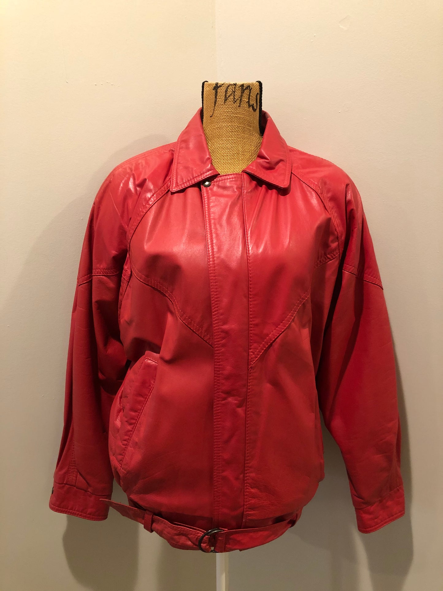 Kingspier Vintage - Zaggara Designs red leather jacket with hidden zipper, slash pockets, inside pocket and a belt at the waist. Size small.