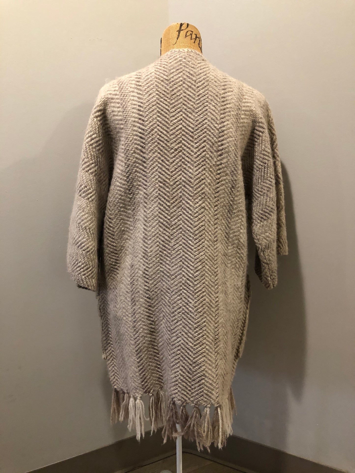 Kingspier Vintage - Daurene Lewis 100% wool hand spun, hand woven and hand made cardigan. The cardigan features two lined patch pockets. two wooden button closures at the top and a wool fringe at the bottom. Made in Annapolis Royal, Nova Scotia.