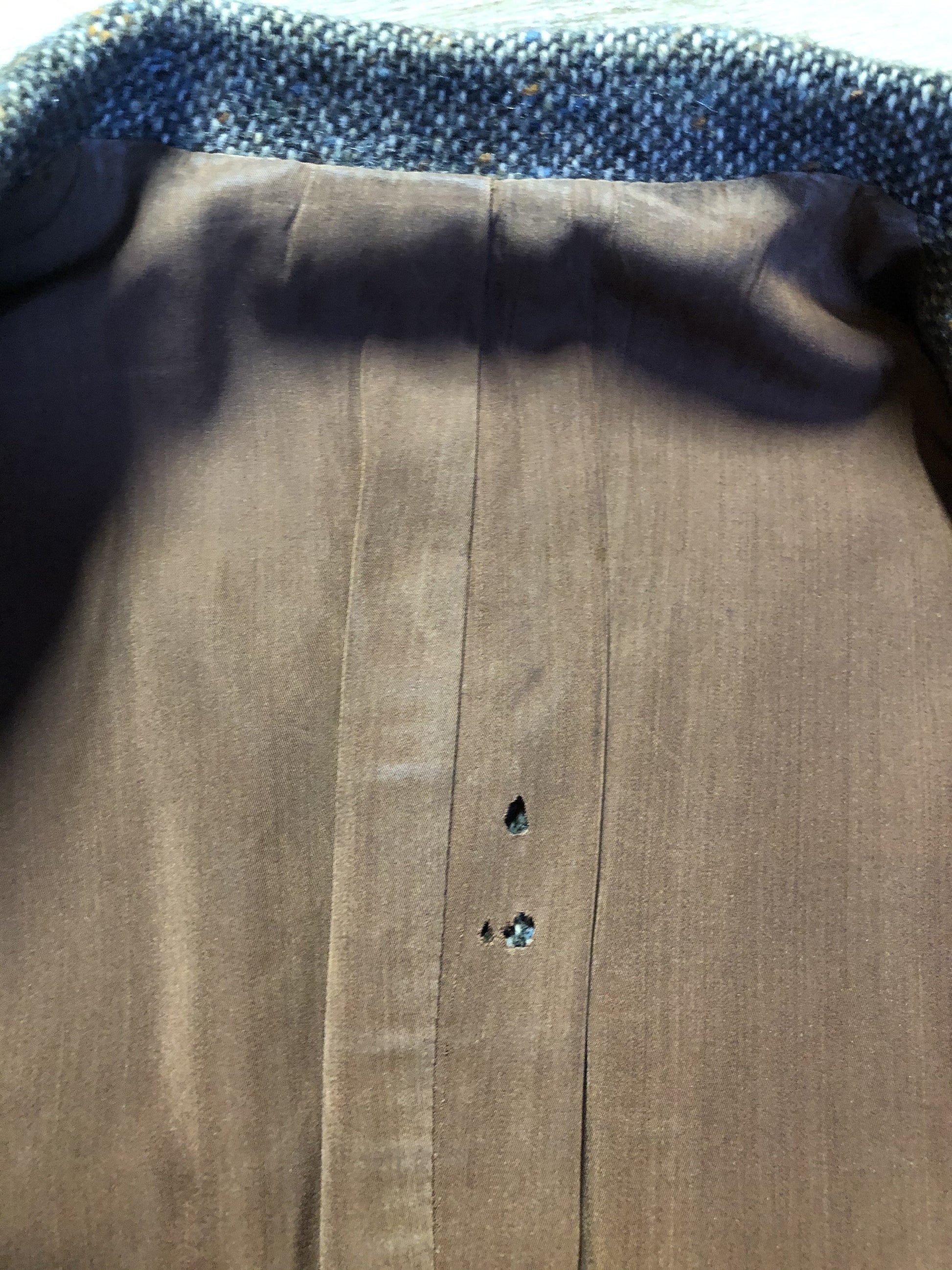 Kingspier Vintage - Donegal handwoven grey with blue and orange flecks 100% wool tweed jacket. This jacket is a two button, notch lapel with two patch pockets, a breast pocket and two inside pockets and a “this I defend” emblem embroidered on the chest. Made in Ireland.