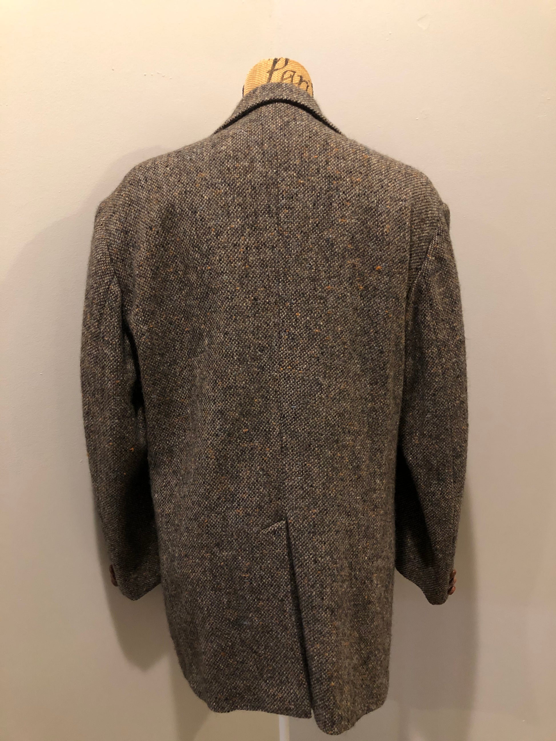Kingspier Vintage - Donegal handwoven grey with blue and orange flecks 100% wool tweed jacket. This jacket is a two button, notch lapel with two patch pockets, a breast pocket and two inside pockets and a “this I defend” emblem embroidered on the chest. Made in Ireland.