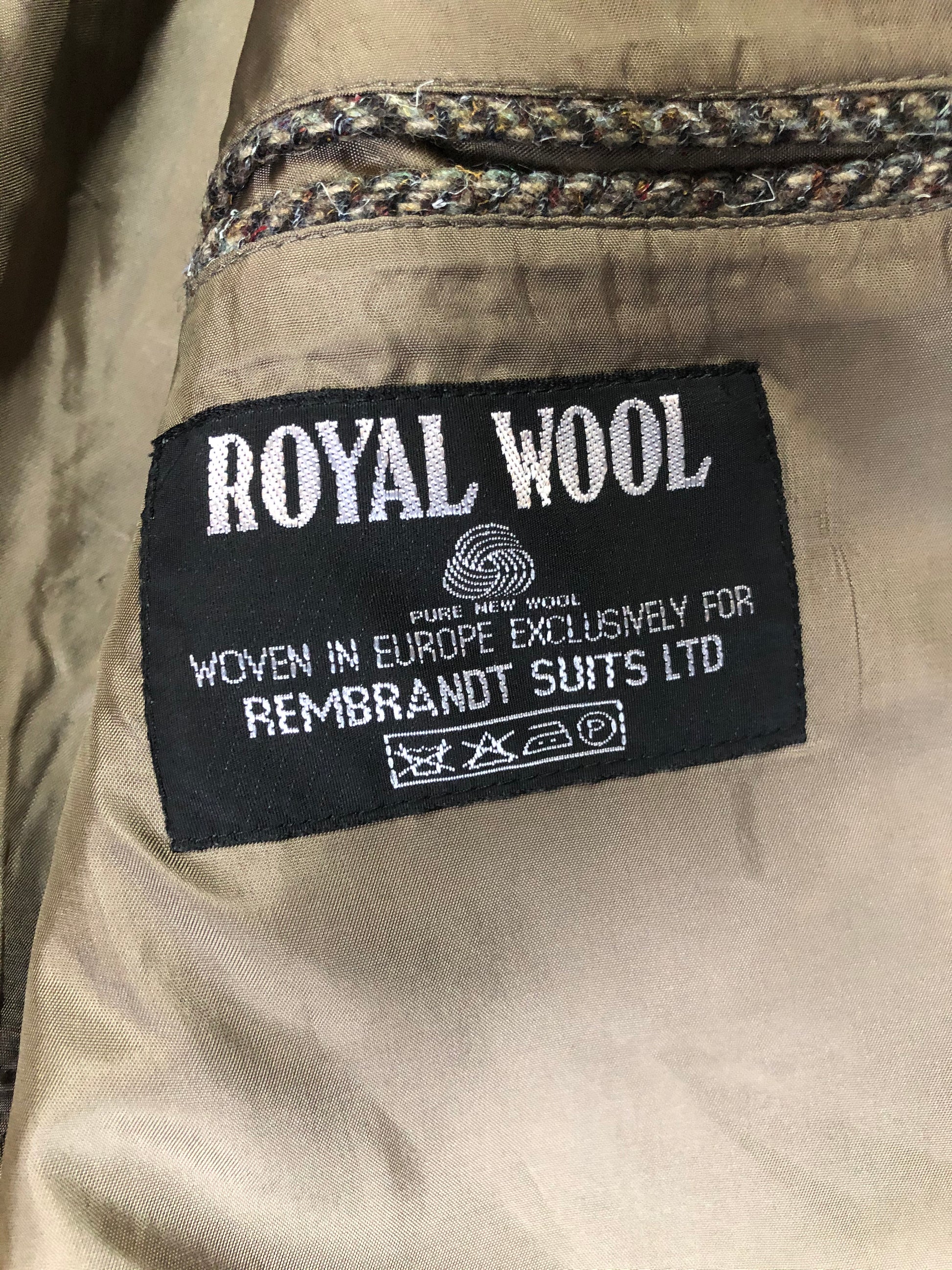 Kingspier Vintage - Paul Henry grey herringbone with flecks blue and rust 100% wool tweed jacket. This jacket is a two button, notch lapel with two flap pockets, a breast pocket and three inside pockets. Made in Europe.