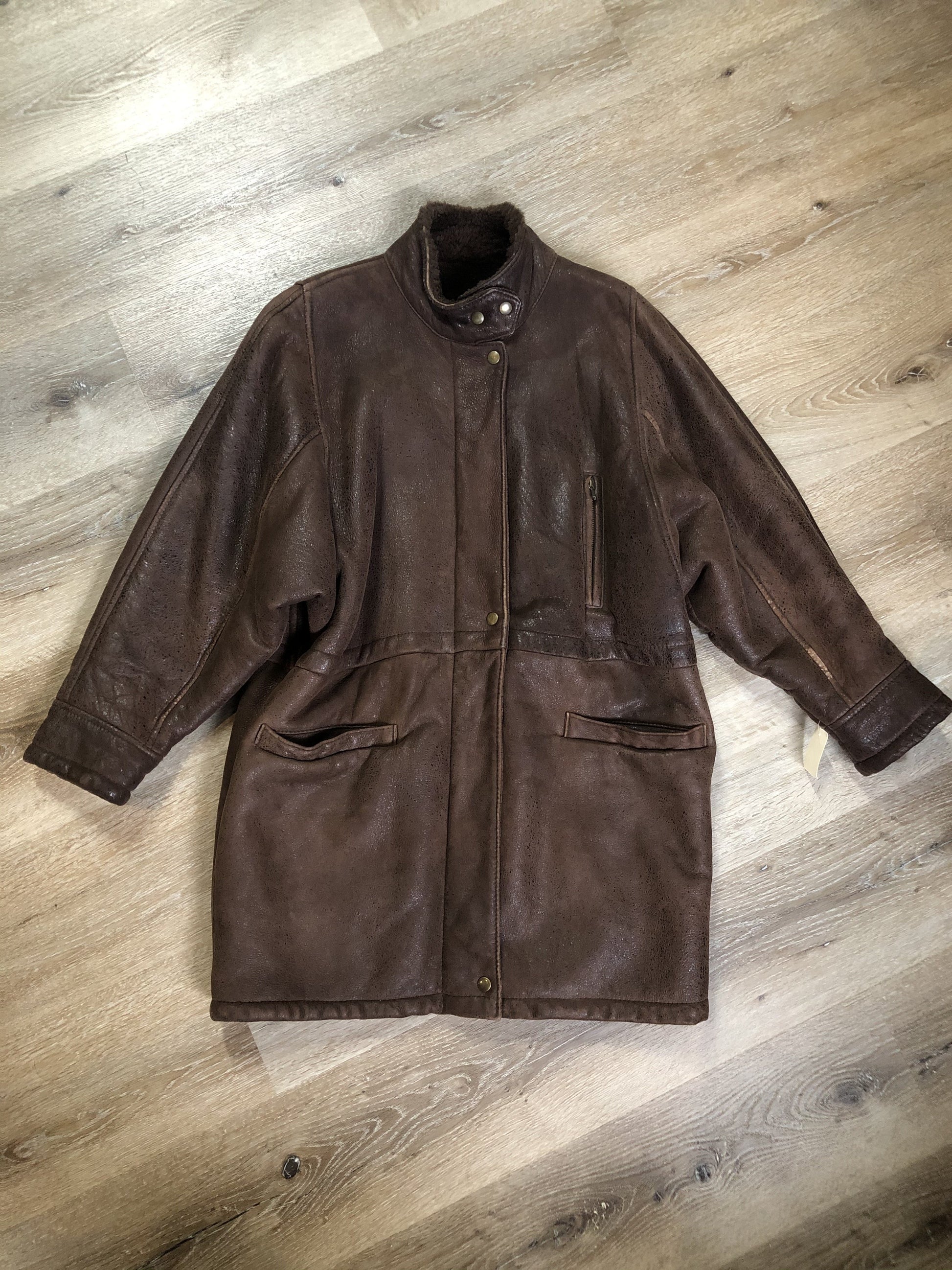 Kingspier Vintage - Jean Claude Poitras medium brown shearling coat. This coat features a speckled texture, shearling lining, zipper and snap closures, one zip pocket on the chest and two welt pockets. Size medium.