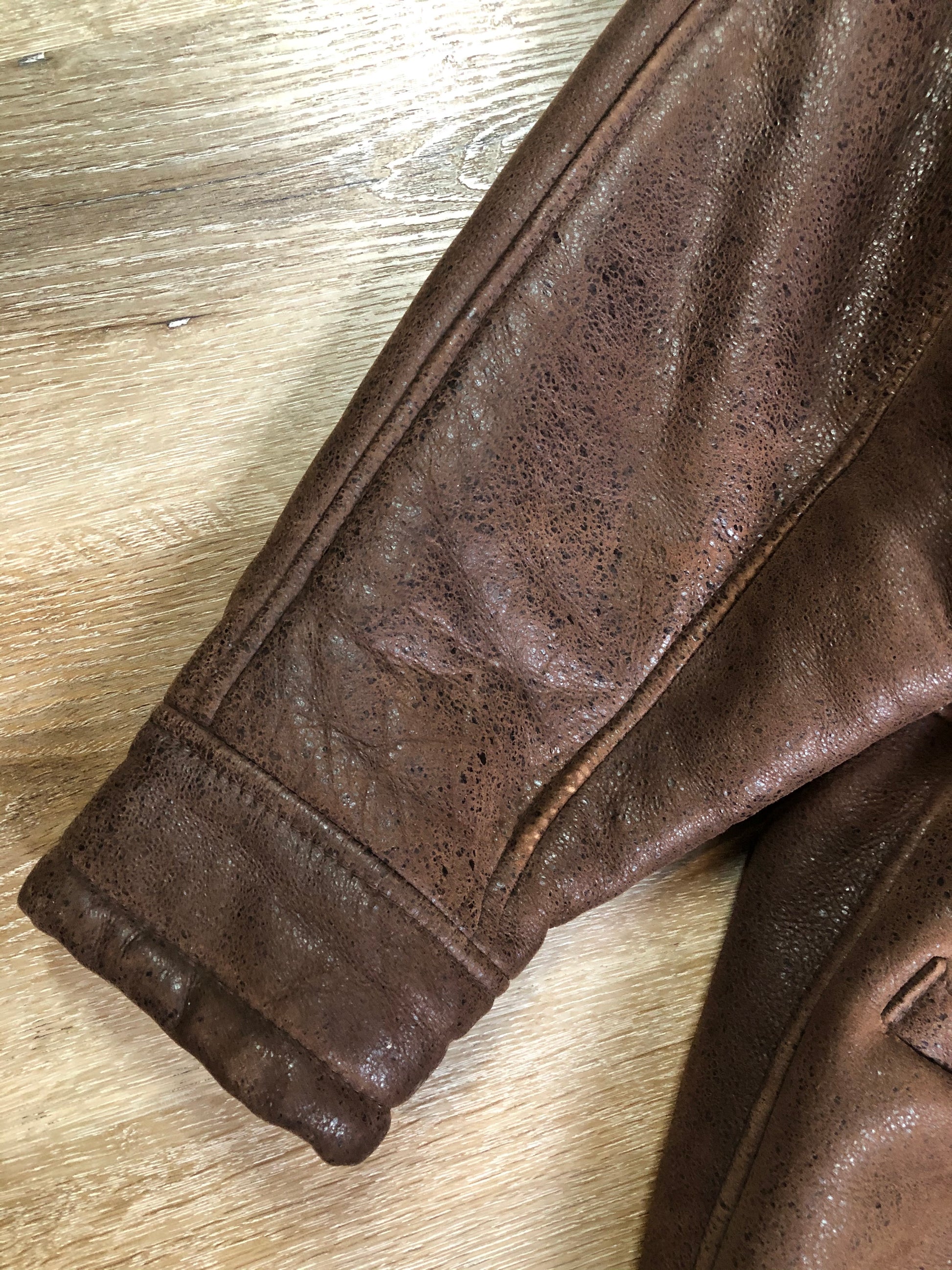 Kingspier Vintage - Jean Claude Poitras medium brown shearling coat. This coat features a speckled texture, shearling lining, zipper and snap closures, one zip pocket on the chest and two welt pockets. Size medium.