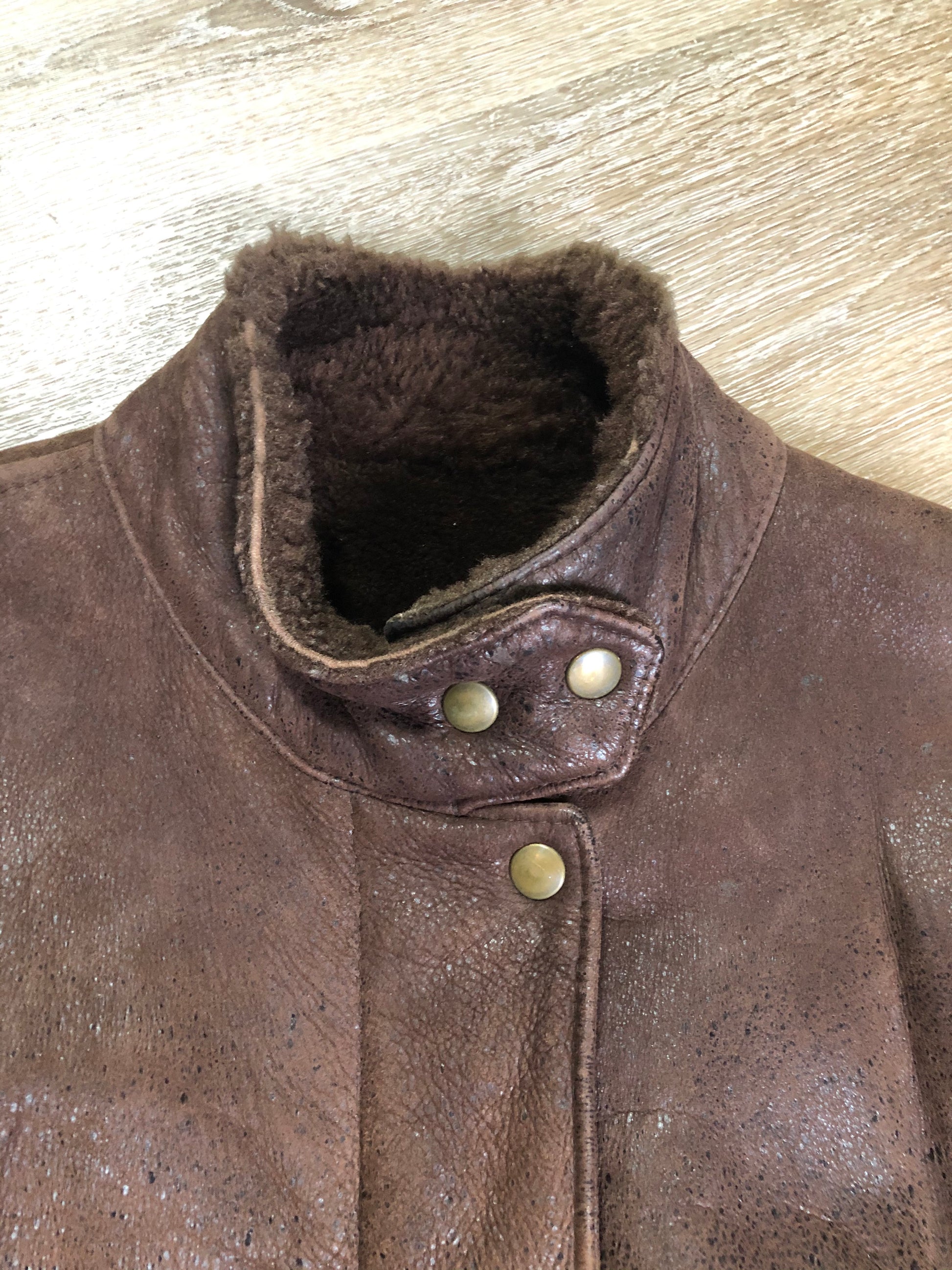 Kingspier Vintage - Jean Claude Poitras medium brown shearling coat. This coat features a speckled texture, shearling lining, zipper and snap closures, one zip pocket on the chest and two welt pockets. Size medium.