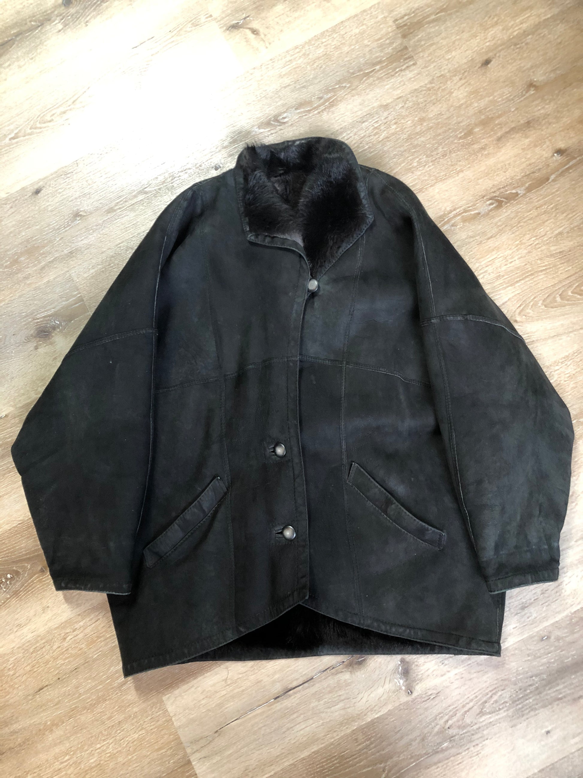 Kingspier Vintage - Black shearling coat with shearling lining, button closures and slash pockets.