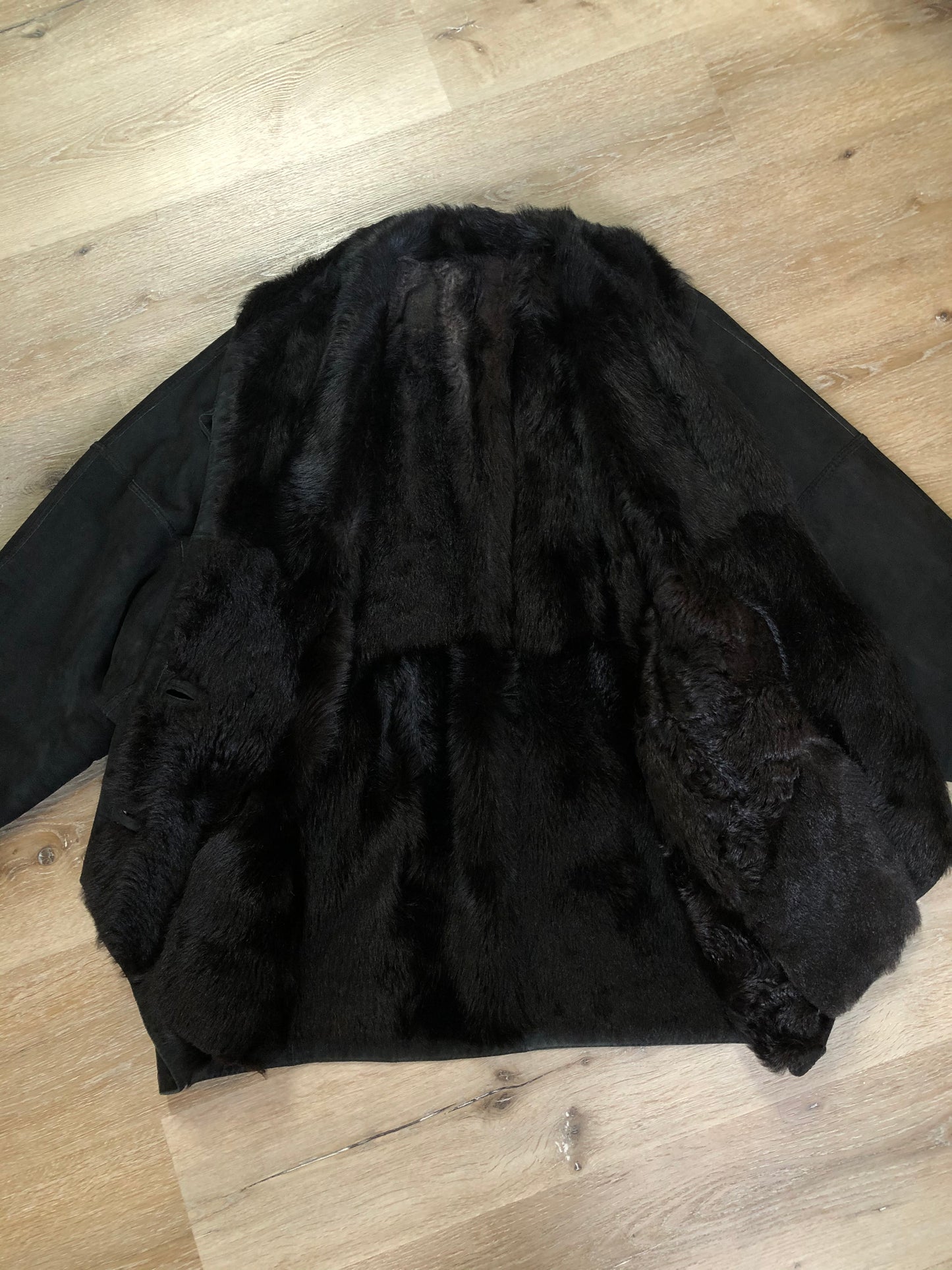 Kingspier Vintage - Black shearling coat with shearling lining, button closures and slash pockets.