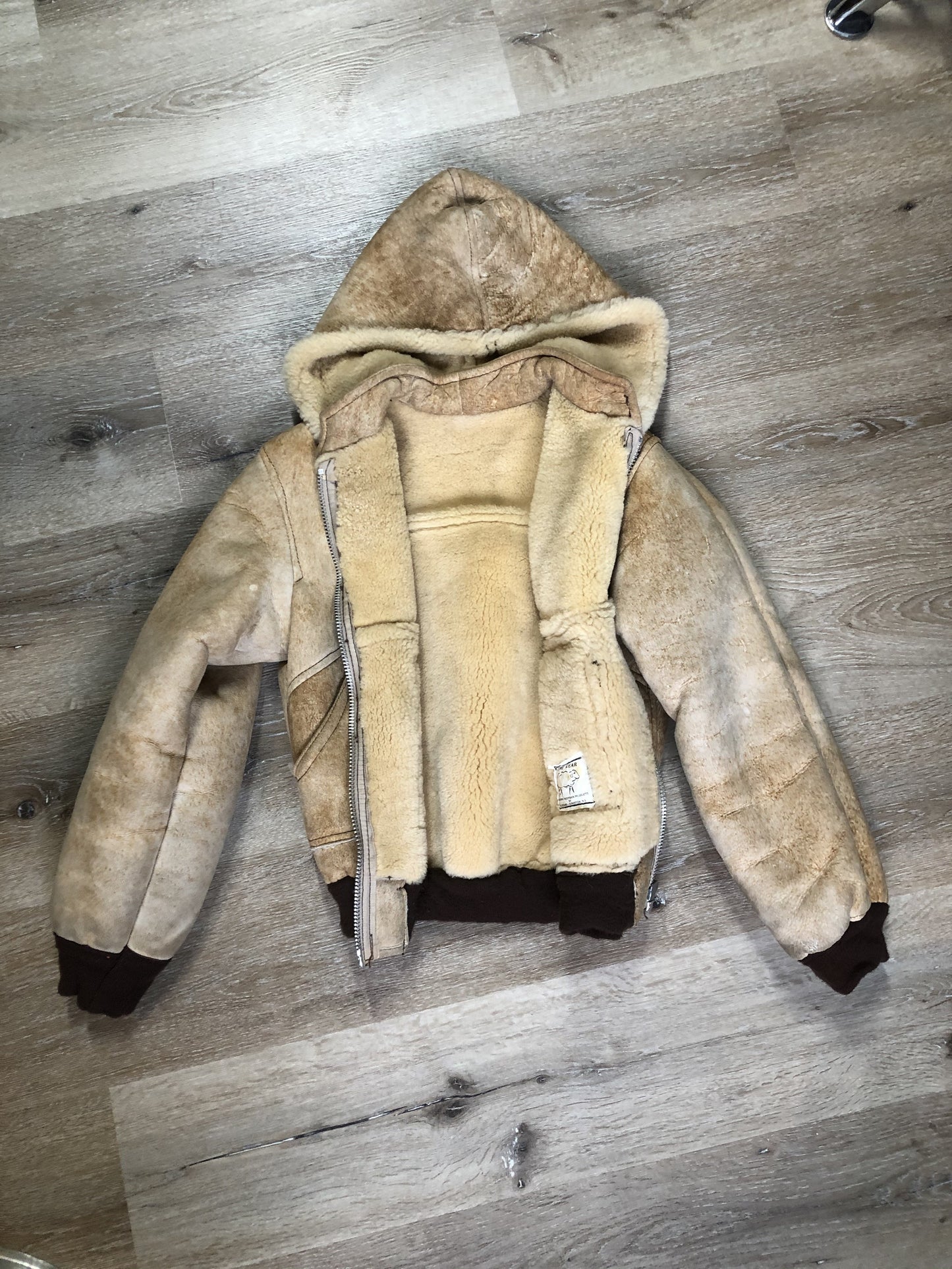 Kingspier Vintage - Ewe Wear, genuine sheepskin hooded bomber style jacket. This jacket features shearling lining, hood, zipper closure and slash pockets. Made in Kingston, Nova Scotia. Size XS.