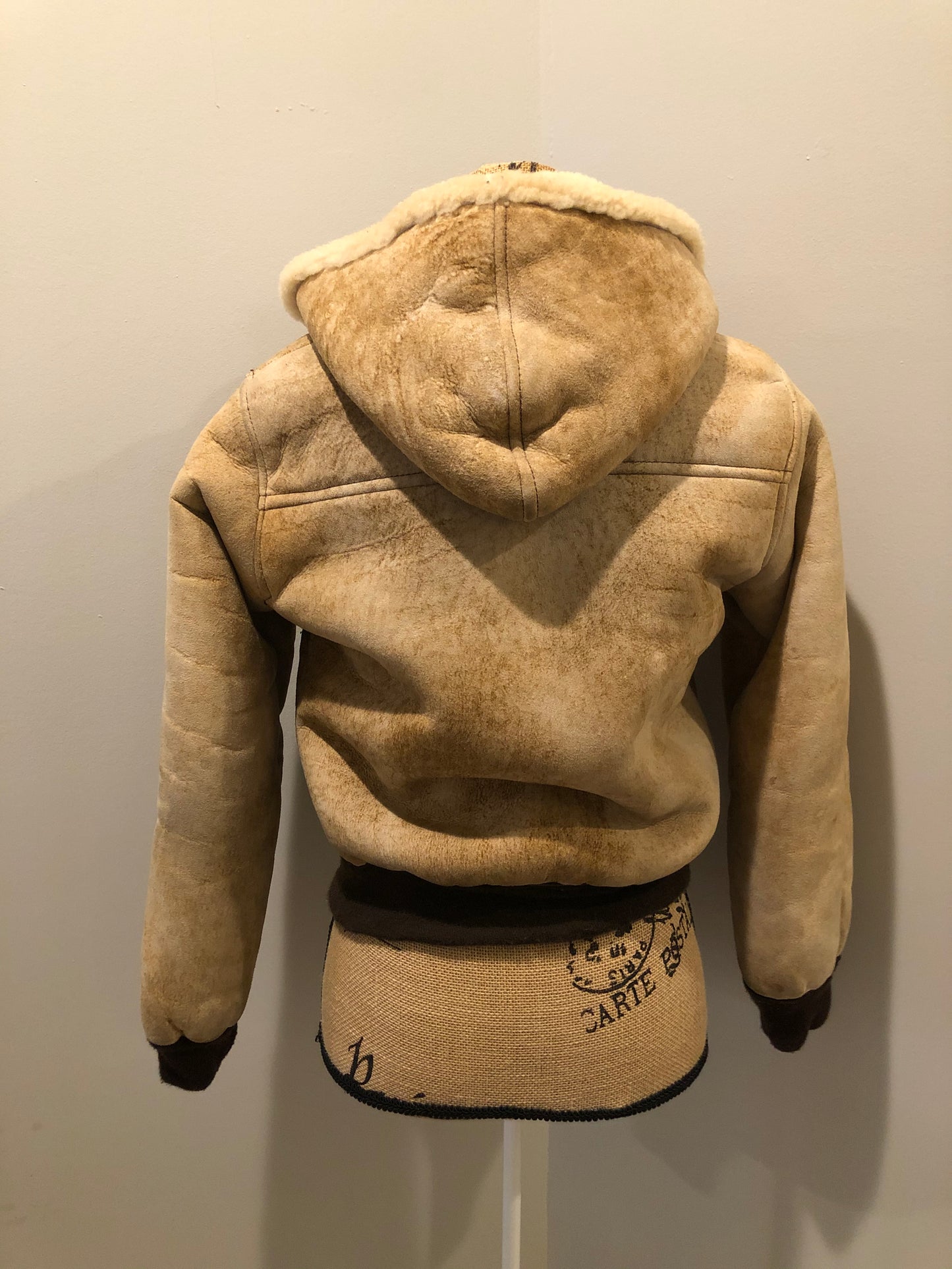 Kingspier Vintage - Ewe Wear, genuine sheepskin hooded bomber style jacket. This jacket features shearling lining, hood, zipper closure and slash pockets. Made in Kingston, Nova Scotia. Size XS.