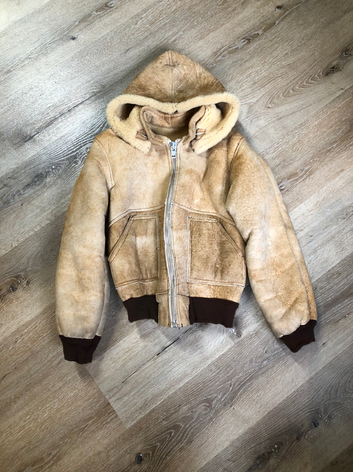 Kingspier Vintage - Ewe Wear, genuine sheepskin hooded bomber style jacket. This jacket features shearling lining, hood, zipper closure and slash pockets. Made in Kingston, Nova Scotia. Size XS.