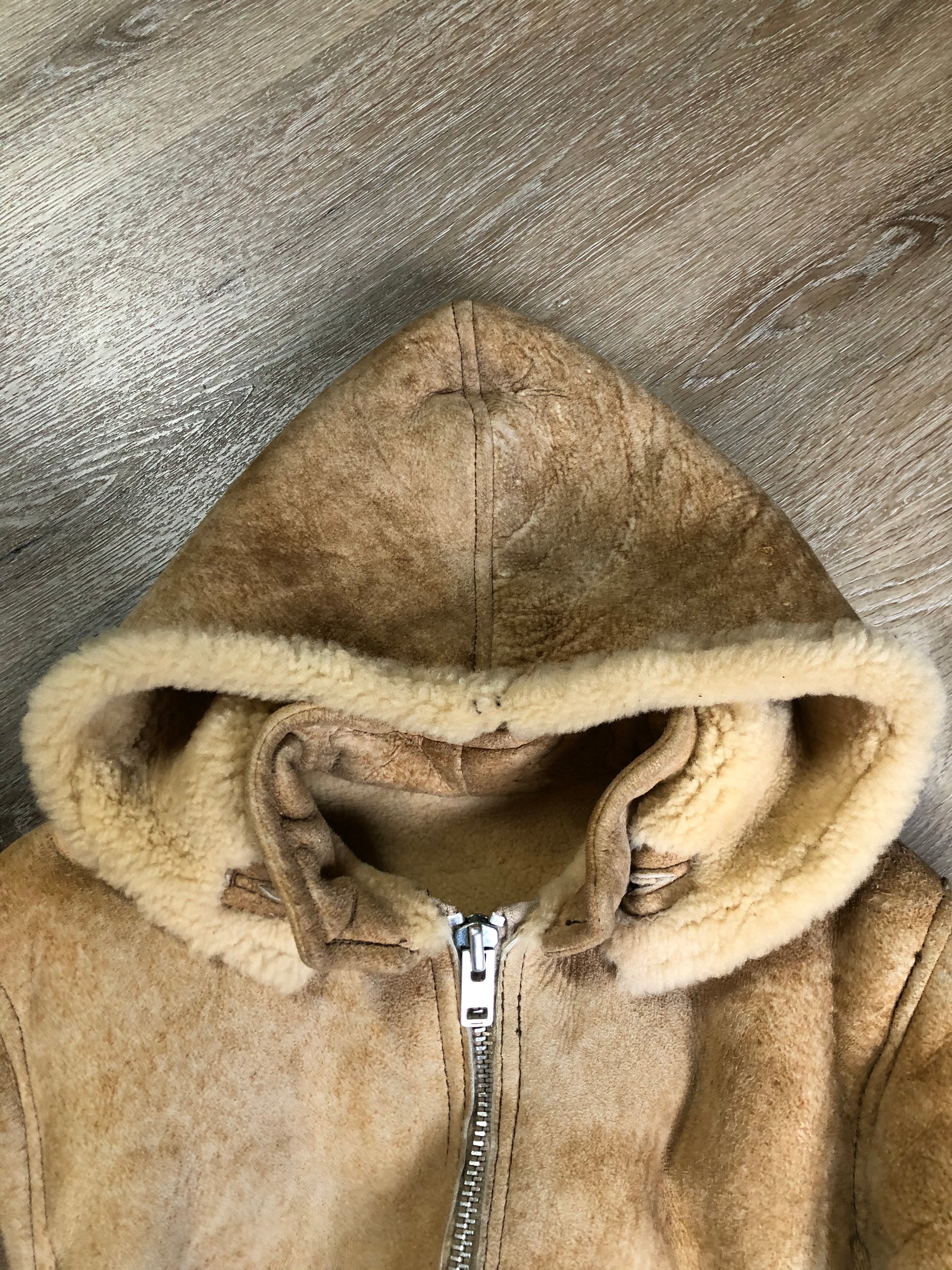 Kingspier Vintage - Ewe Wear, genuine sheepskin hooded bomber style jacket. This jacket features shearling lining, hood, zipper closure and slash pockets. Made in Kingston, Nova Scotia. Size XS.
