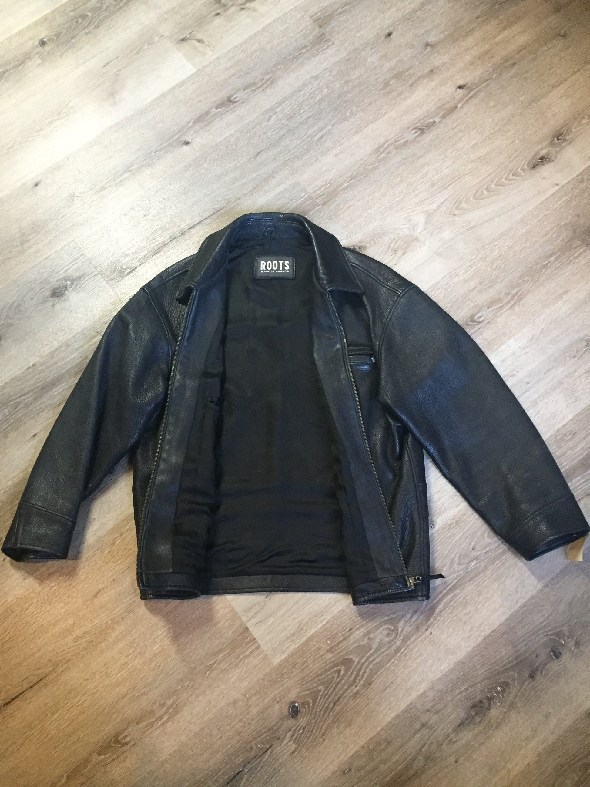 Kingspier Vintage - Roots black pebbled leather jacket with two vertical zip pockets and one zip pocket on the chest. Made in Canada. Size medium.