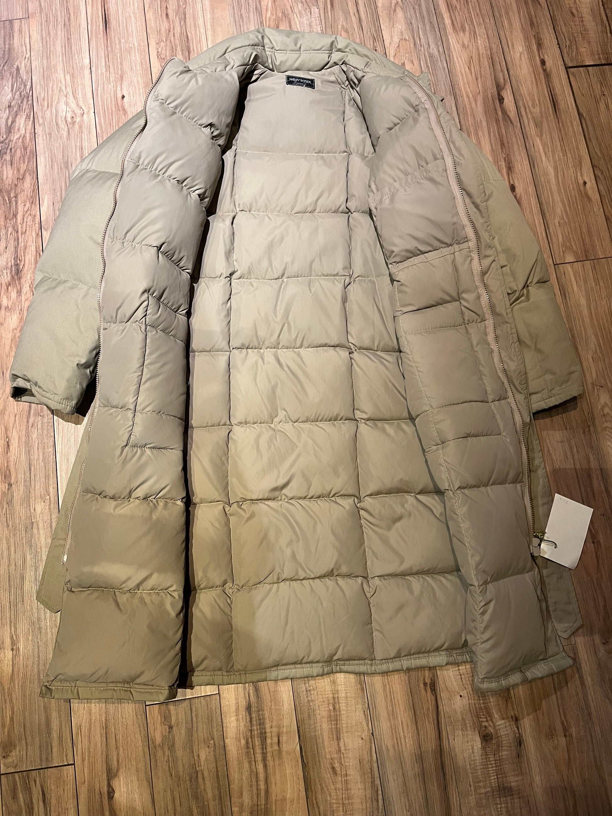 Harry Rosen Sport beige down-filled long puffer coat with belt, zipper closures and two front flap pockets.
Made in Canada
Size 40