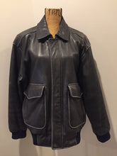Load image into Gallery viewer, Kingspier Vintage - Black leather pilot jacket with zipper and snap closures, flap pockets, knit trim, inside pocket and plane pattern on inside lining. Size large. 
