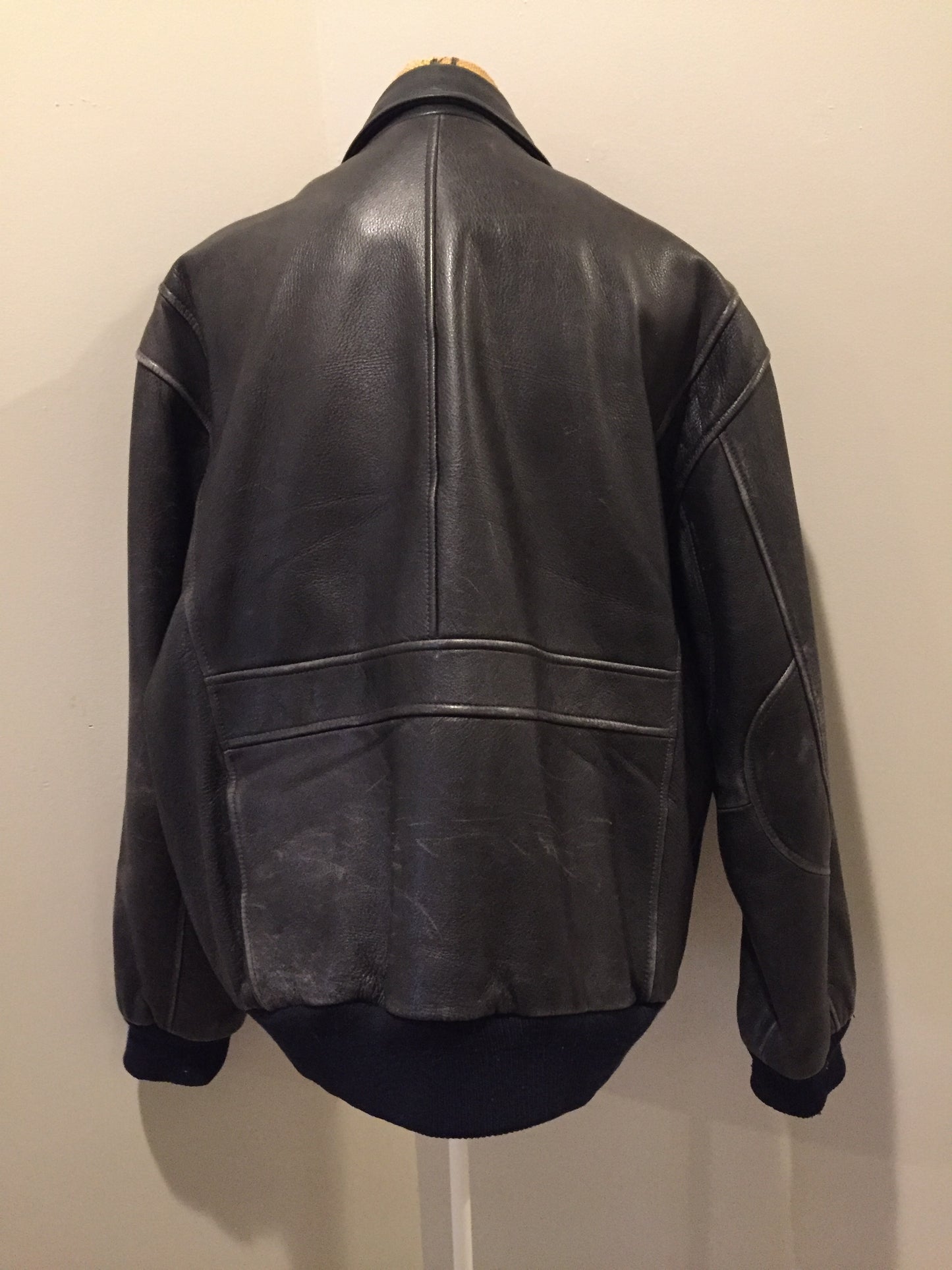 Kingspier Vintage - Black leather pilot jacket with zipper and snap closures, flap pockets, knit trim, inside pocket and plane pattern on inside lining. Size large.
