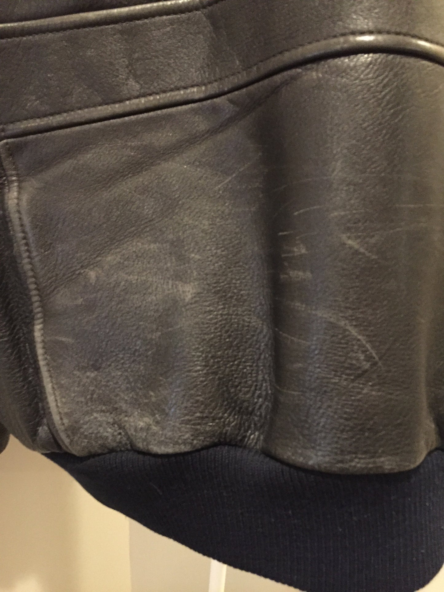 Kingspier Vintage - Black leather pilot jacket with zipper and snap closures, flap pockets, knit trim, inside pocket and plane pattern on inside lining. Size large.