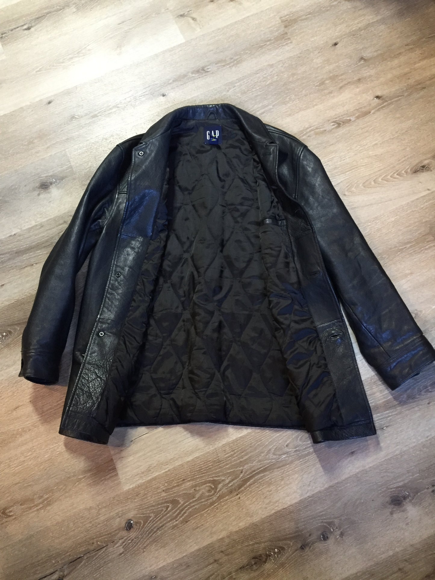 Kingspier Vintage - Gap black leather jacket with button closures, slash pockets, inside pocket and quilted lining. Size large.