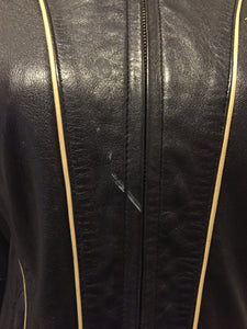 Kingspier Vintage - Baby Phat black leather moto jacket with gold piping and “Baby Phat” embroidered on the chest, front zipper and two vertical zip pockets. A pattern is stitched into the elbows and “Baby Phat” is stitched across the back. Size small.