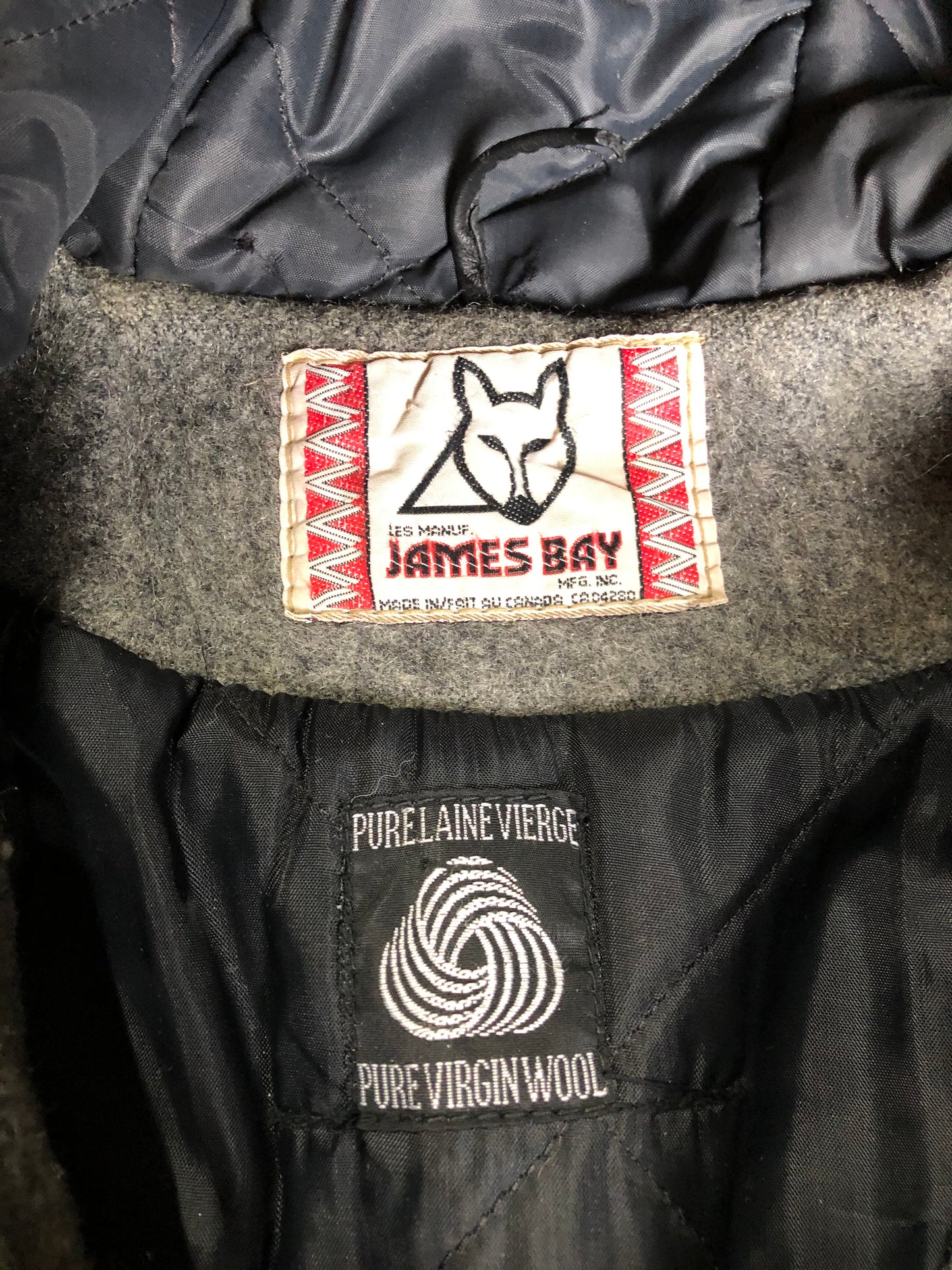 Kingspier Vintage - James Bay pure virgin wool northern parka in grey. This parka features a hood with white faux fur trim, zipper closure, quilted lining, knit inside hidden cuffs, hand stitched detail around the patch pockets and hem, felt seal appliqués in the front and a lovely arctic landscape on the back. Made in Canada.
