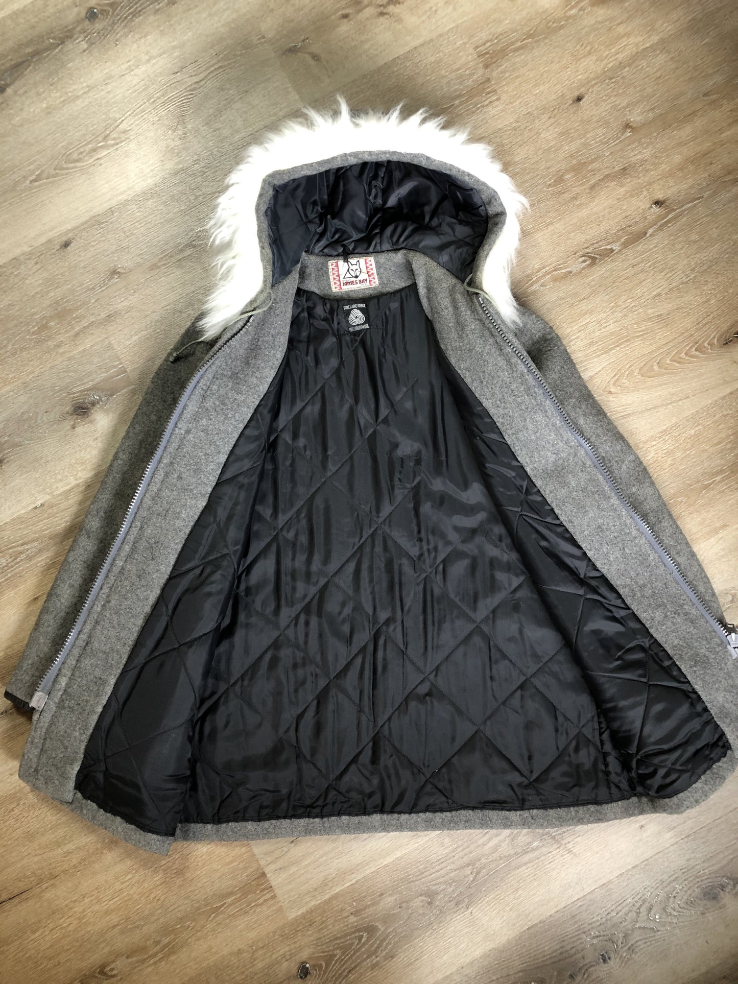Kingspier Vintage - James Bay pure virgin wool northern parka in grey. This parka features a hood with white faux fur trim, zipper closure, quilted lining, knit inside hidden cuffs, hand stitched detail around the patch pockets and hem, felt seal appliqués in the front and a lovely arctic landscape on the back. Made in Canada.