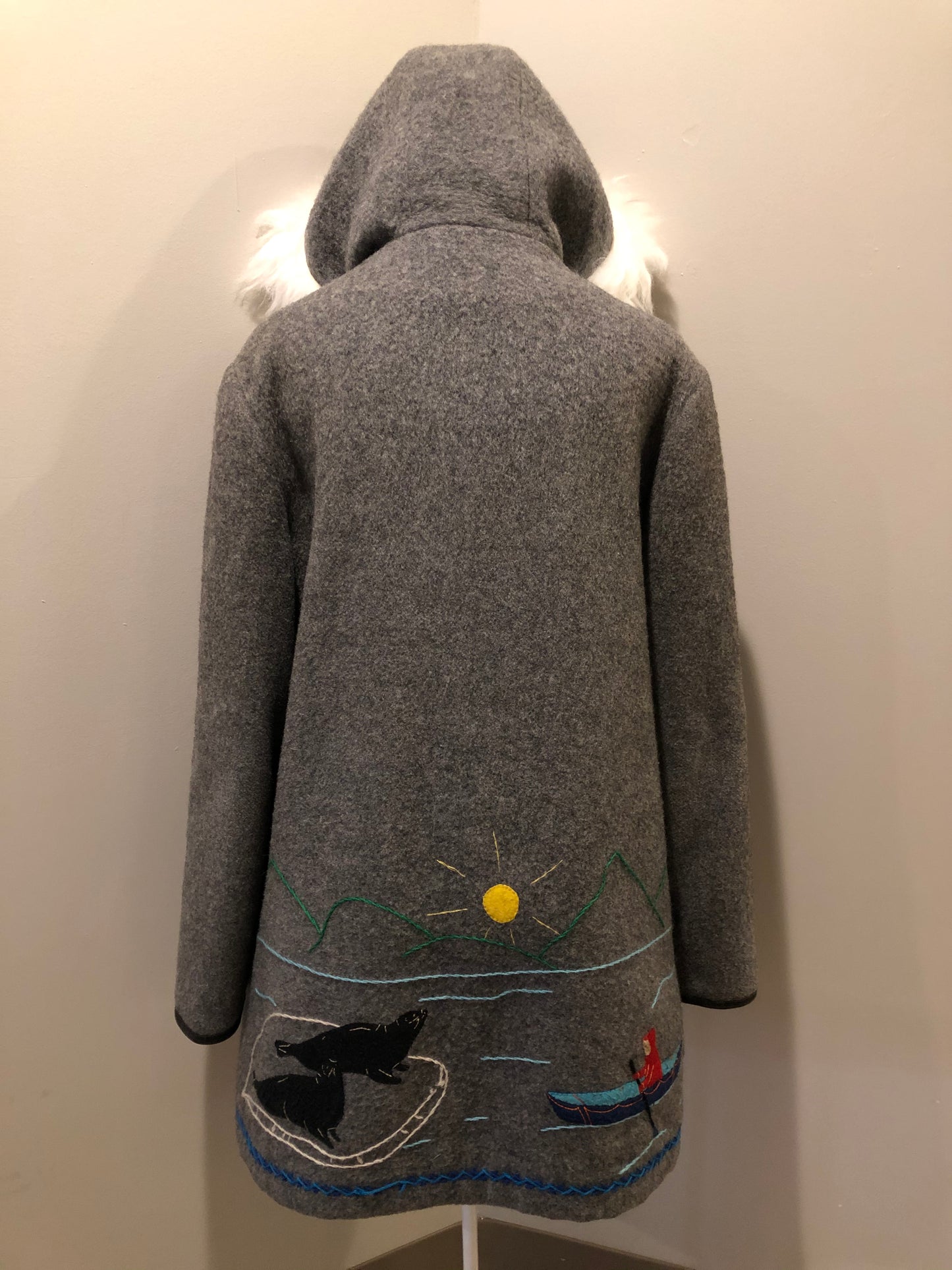 Kingspier Vintage - James Bay pure virgin wool northern parka in grey. This parka features a hood with white faux fur trim, zipper closure, quilted lining, knit inside hidden cuffs, hand stitched detail around the patch pockets and hem, felt seal appliqués in the front and a lovely arctic landscape on the back. Made in Canada.