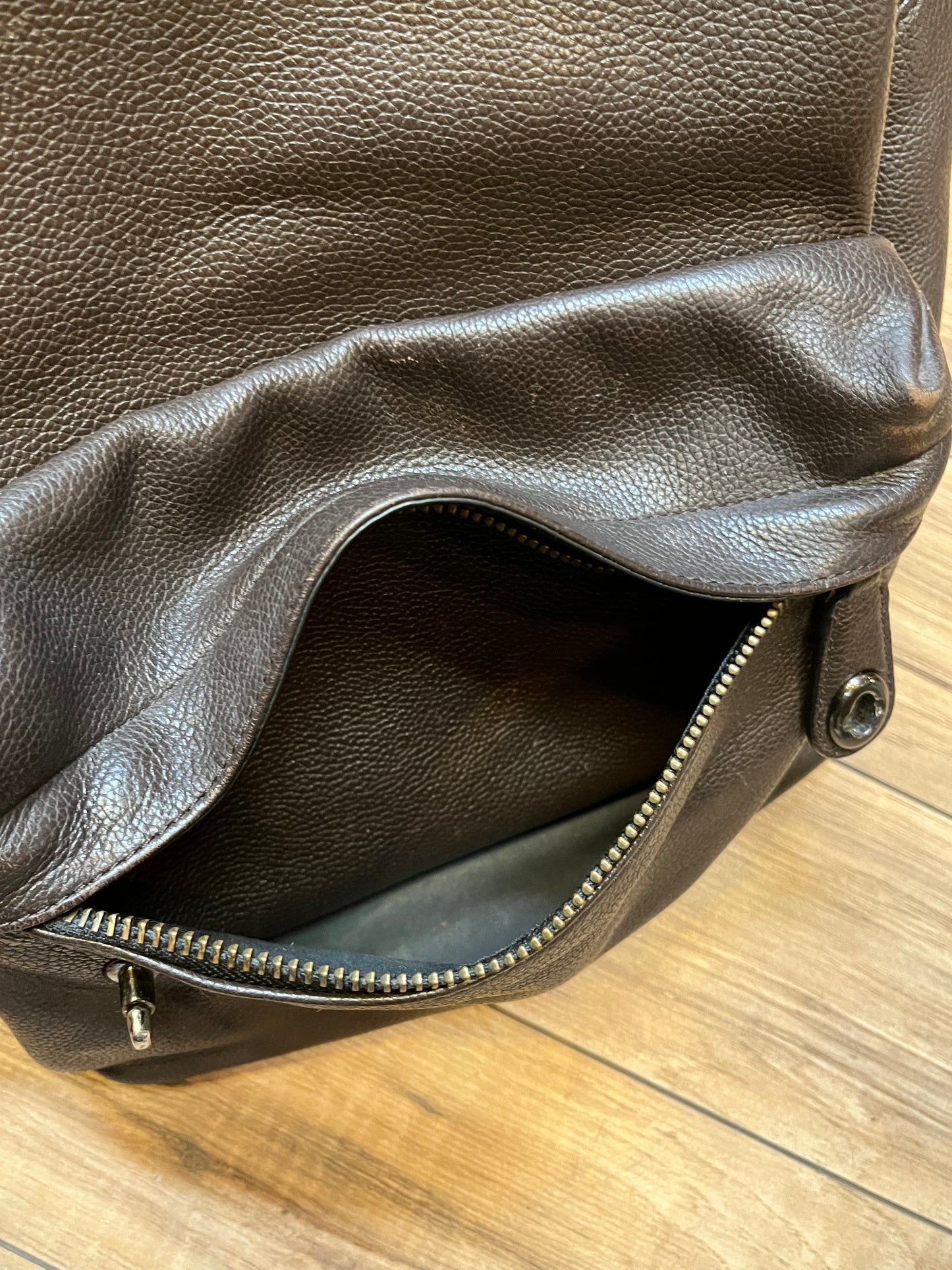 Authentic Coach brown pebble leather knapsack with adjustable shoulder straps, multiple pockets inside the large main compartment and one small compartment on the front with turn key detail.