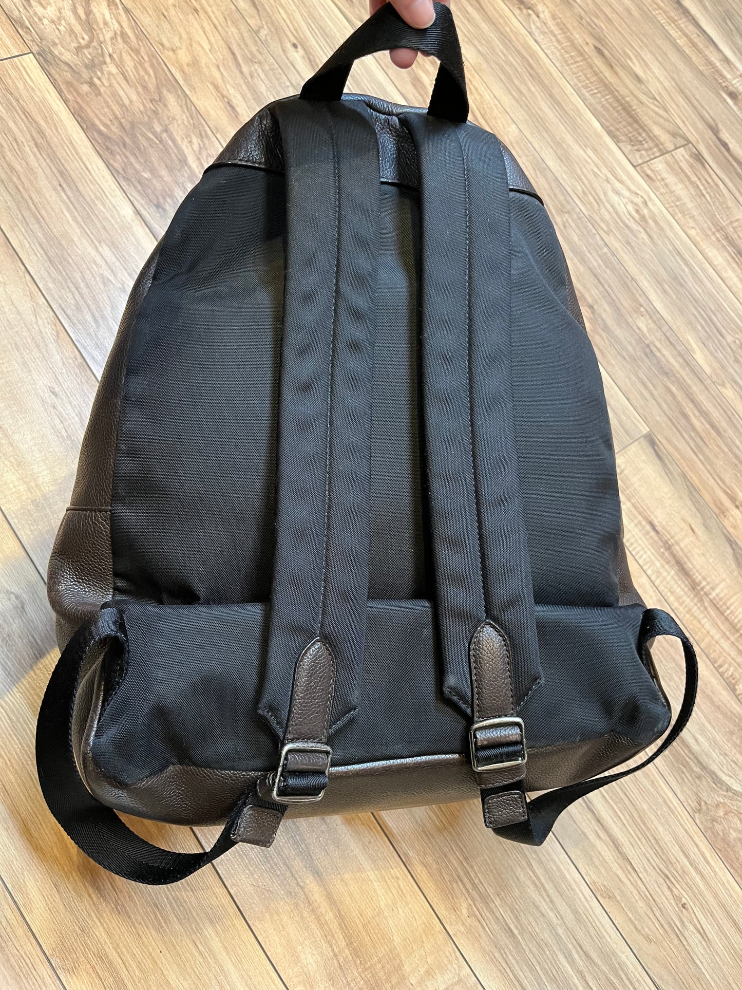 Authentic Coach brown pebble leather knapsack with adjustable shoulder straps, multiple pockets inside the large main compartment and one small compartment on the front with turn key detail.