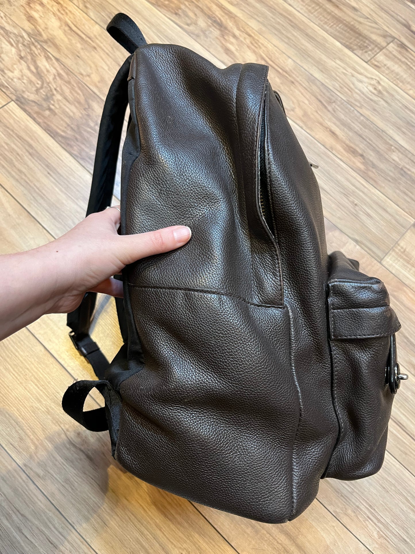 Authentic Coach brown pebble leather knapsack with adjustable shoulder straps, multiple pockets inside the large main compartment and one small compartment on the front with turn key detail.