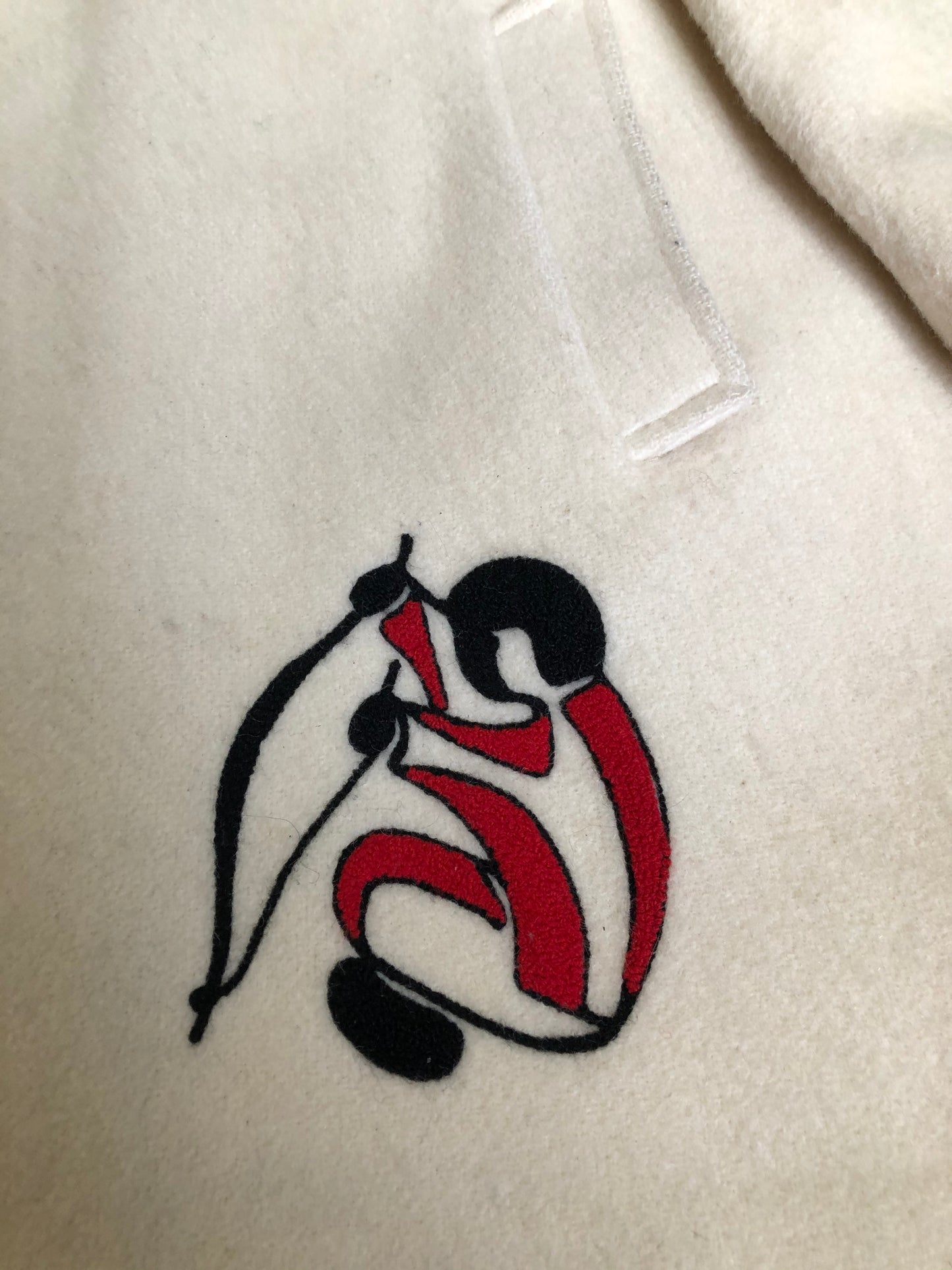 Kingspier Vintage - Canadian Sportswear pure virgin wool northern parka in cream. This parka features a hood with white fur trim, zipper closure, quilted lining, slash pockets, felt fire making design appliqués on the front and canoeing scene design on the back. Made in Canada.