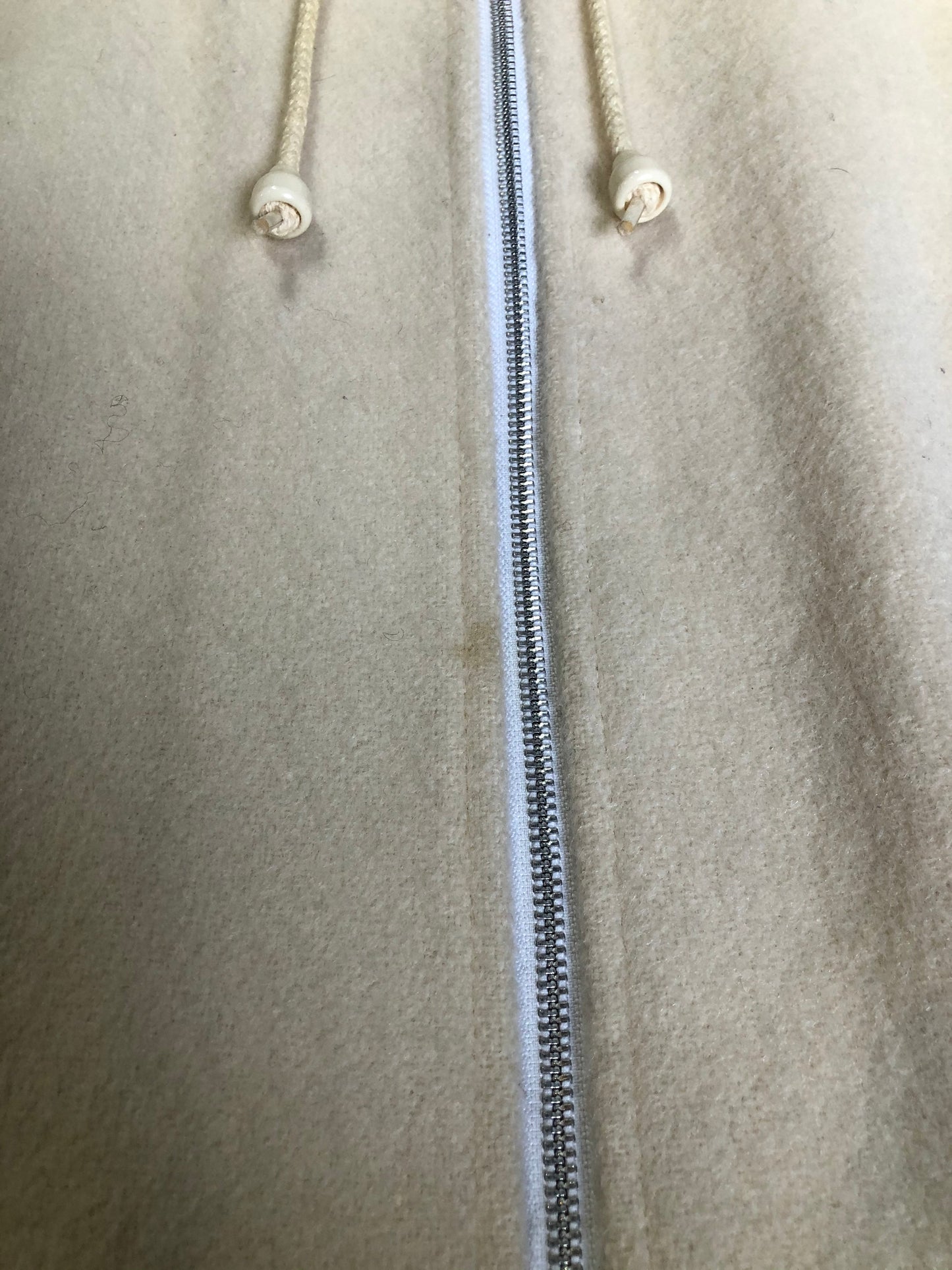 Kingspier Vintage - Canadian Sportswear pure virgin wool northern parka in cream. This parka features a hood with white fur trim, zipper closure, quilted lining, slash pockets, felt fire making design appliqués on the front and canoeing scene design on the back. Made in Canada.