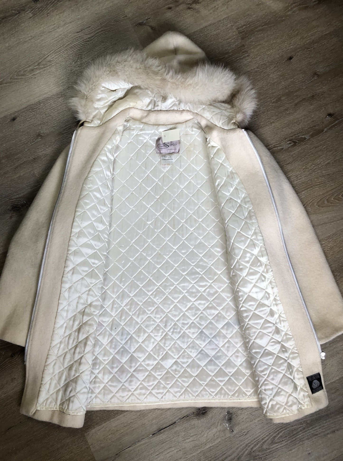 Kingspier Vintage - Canadian Sportswear pure virgin wool northern parka in cream. This parka features a hood with white fur trim, zipper closure, quilted lining, slash pockets, felt fire making design appliqués on the front and canoeing scene design on the back. Made in Canada.