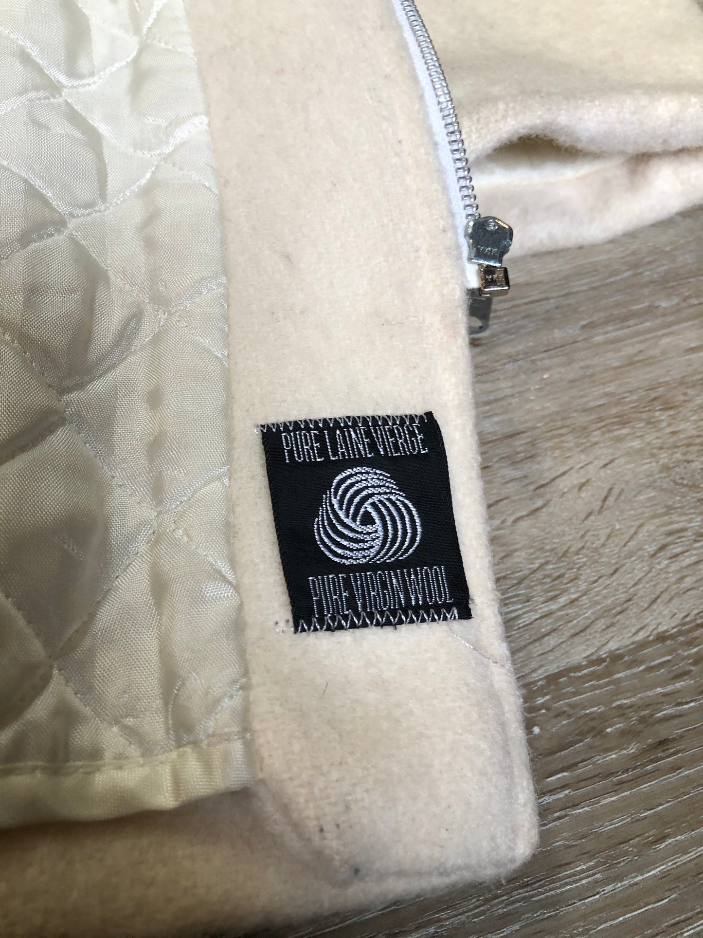 Kingspier Vintage - Canadian Sportswear pure virgin wool northern parka in cream. This parka features a hood with white fur trim, zipper closure, quilted lining, slash pockets, felt fire making design appliqués on the front and canoeing scene design on the back. Made in Canada.