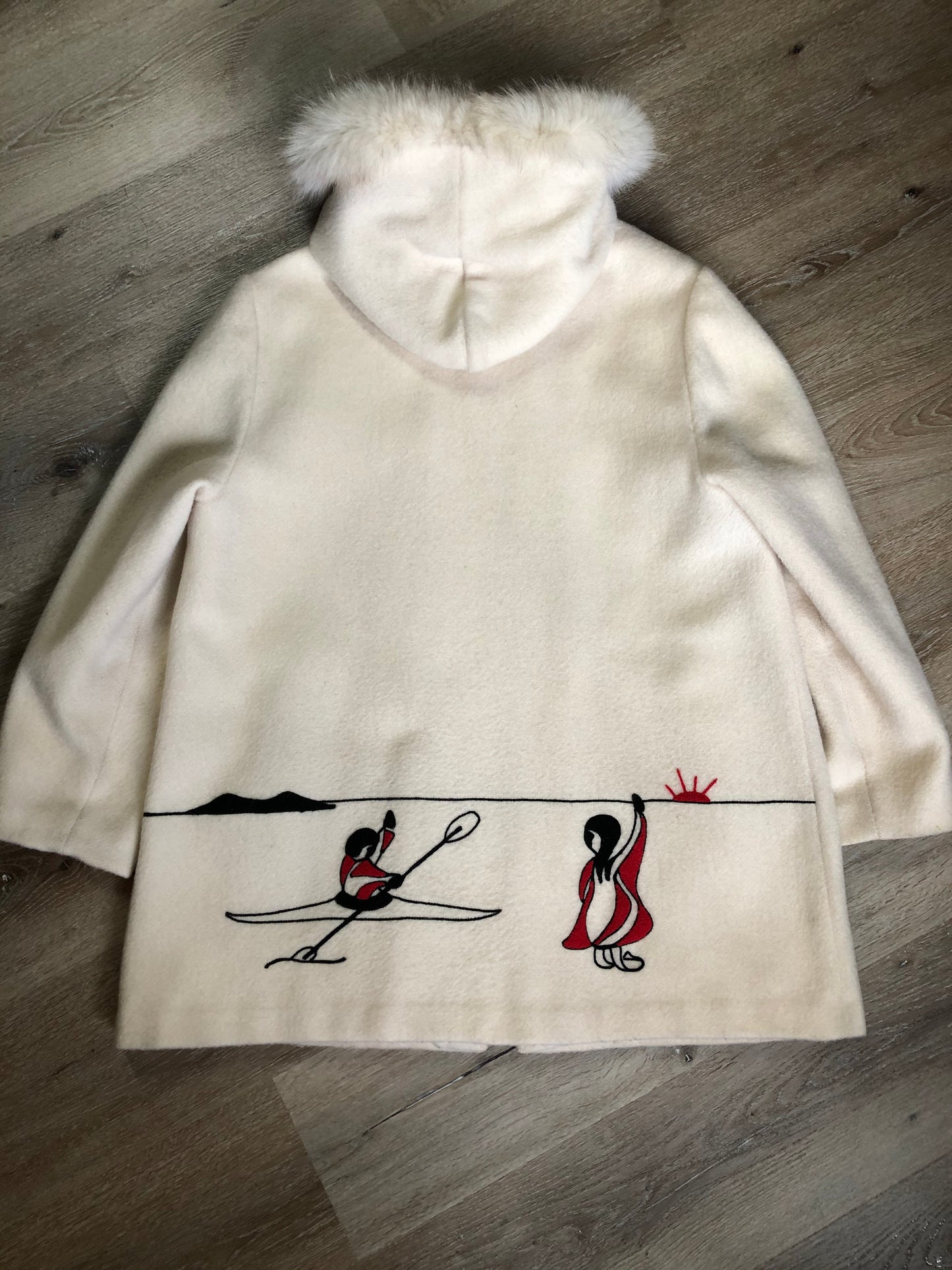 Kingspier Vintage - Canadian Sportswear pure virgin wool northern parka in cream. This parka features a hood with white fur trim, zipper closure, quilted lining, slash pockets, felt fire making design appliqués on the front and canoeing scene design on the back. Made in Canada.