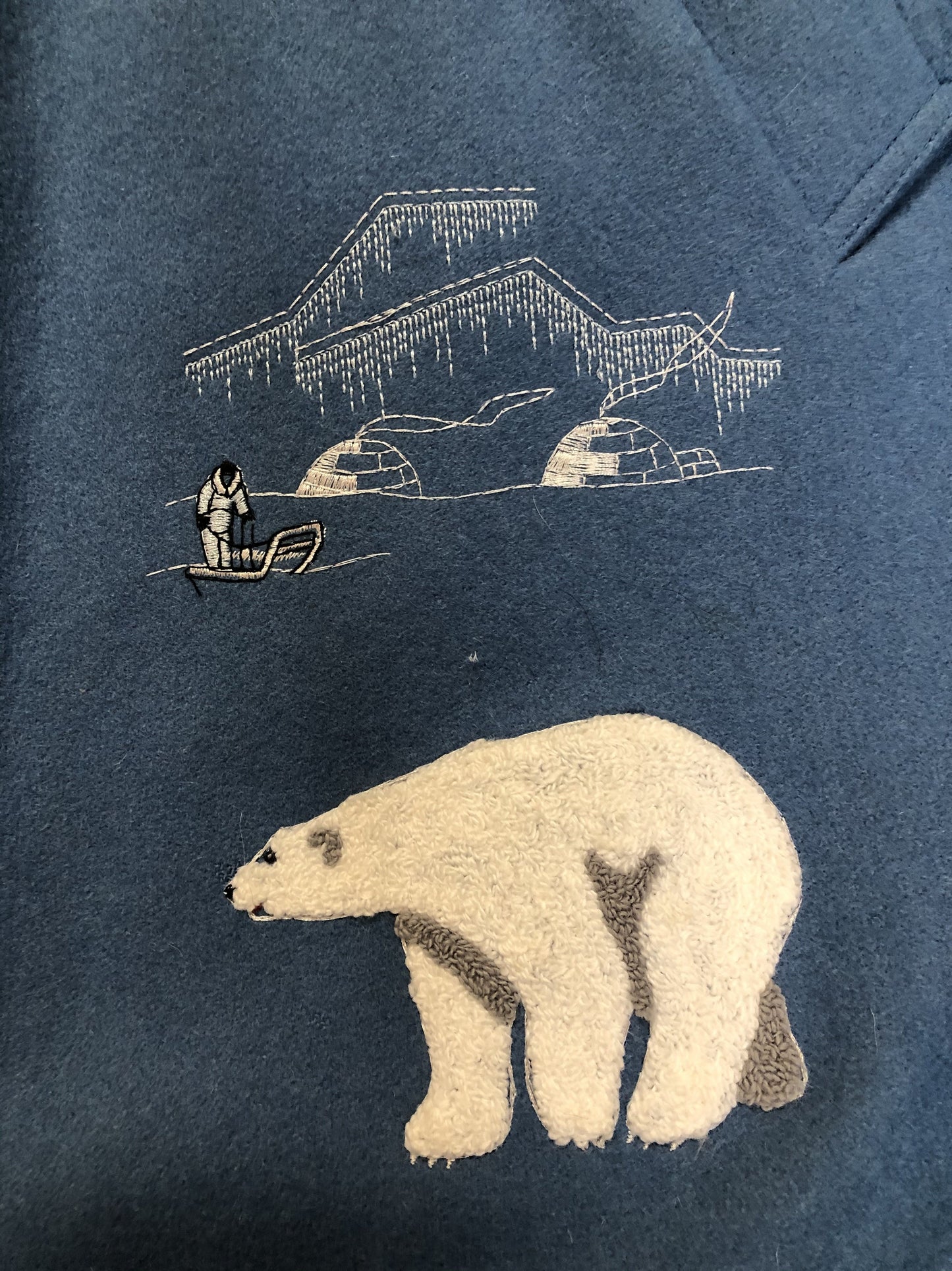 Kingspier Vintage - Northern Sun pure virgin wool northern parka in light blue. This parka features a hood with white fur trim, zipper closure, quilted lining, slash pockets, hidden inside knit cuffs, embroidered polar bear design on the front and back. Made in Canada.